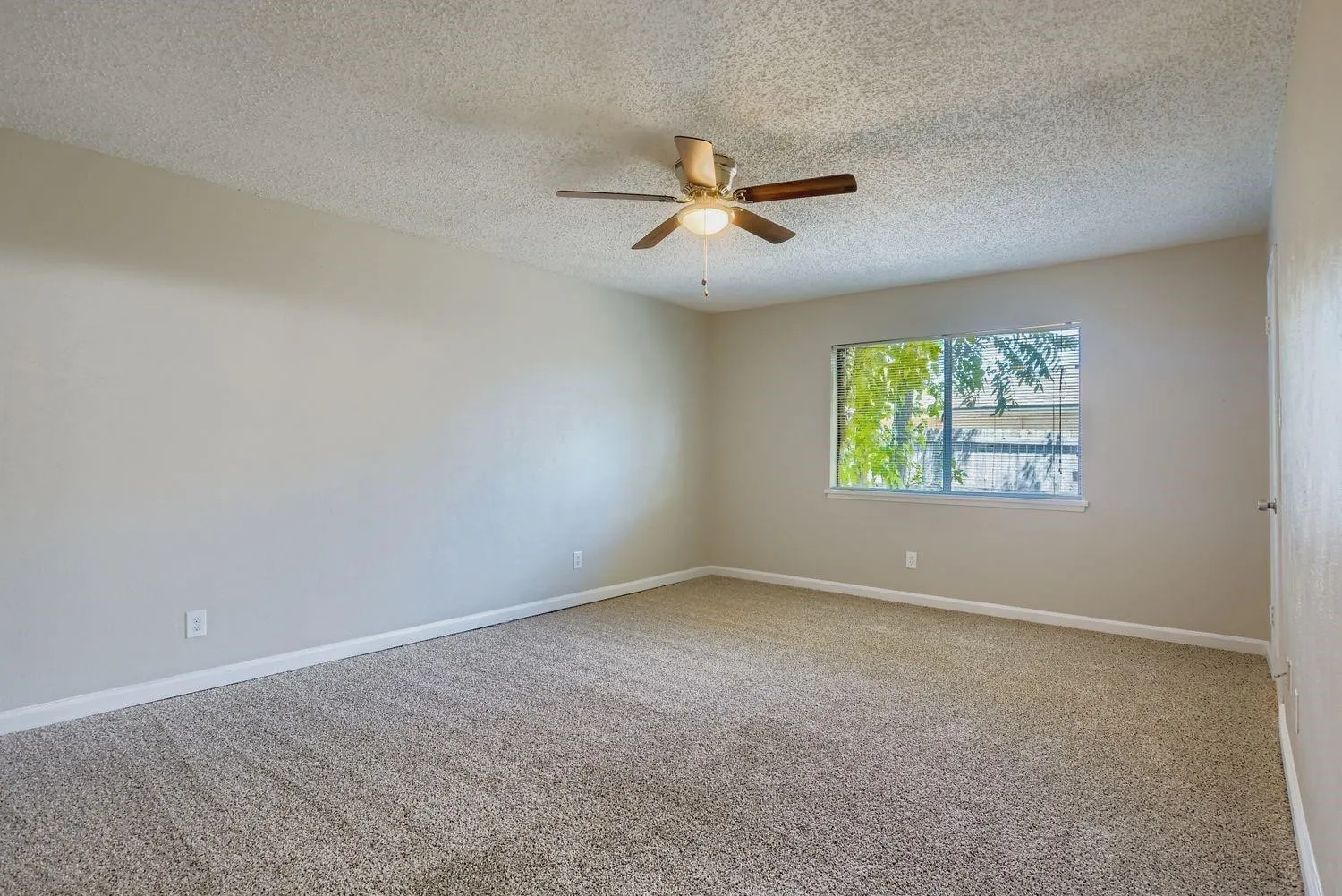 Neutral-toned walls, textured ceiling, and carpeting