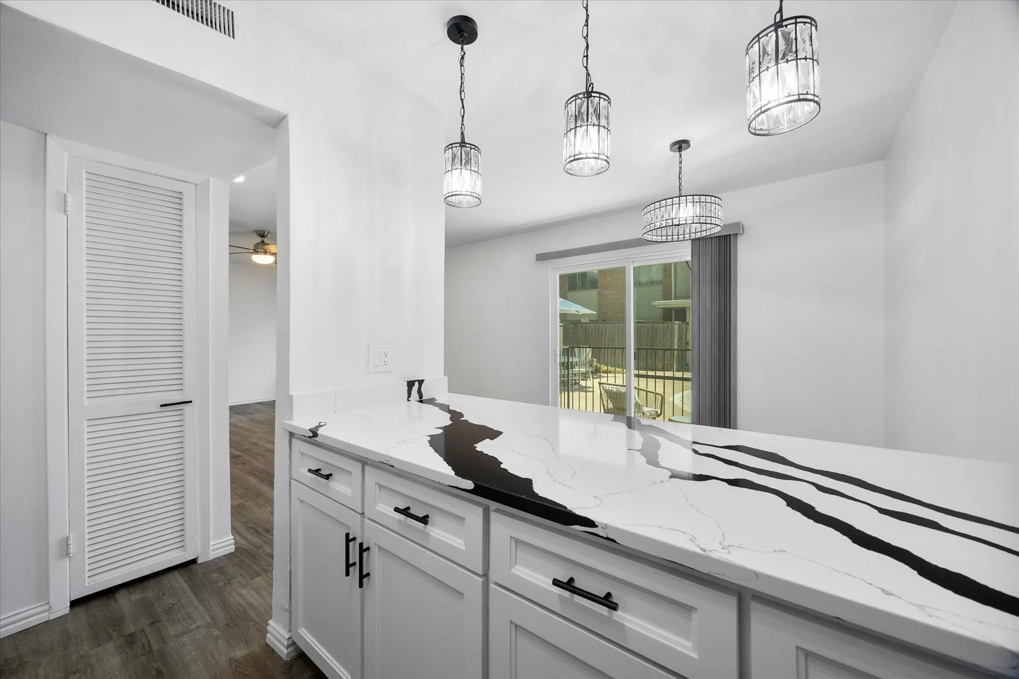 Kitchen with updated finishes and views toward the dining area, courtyard and pool.