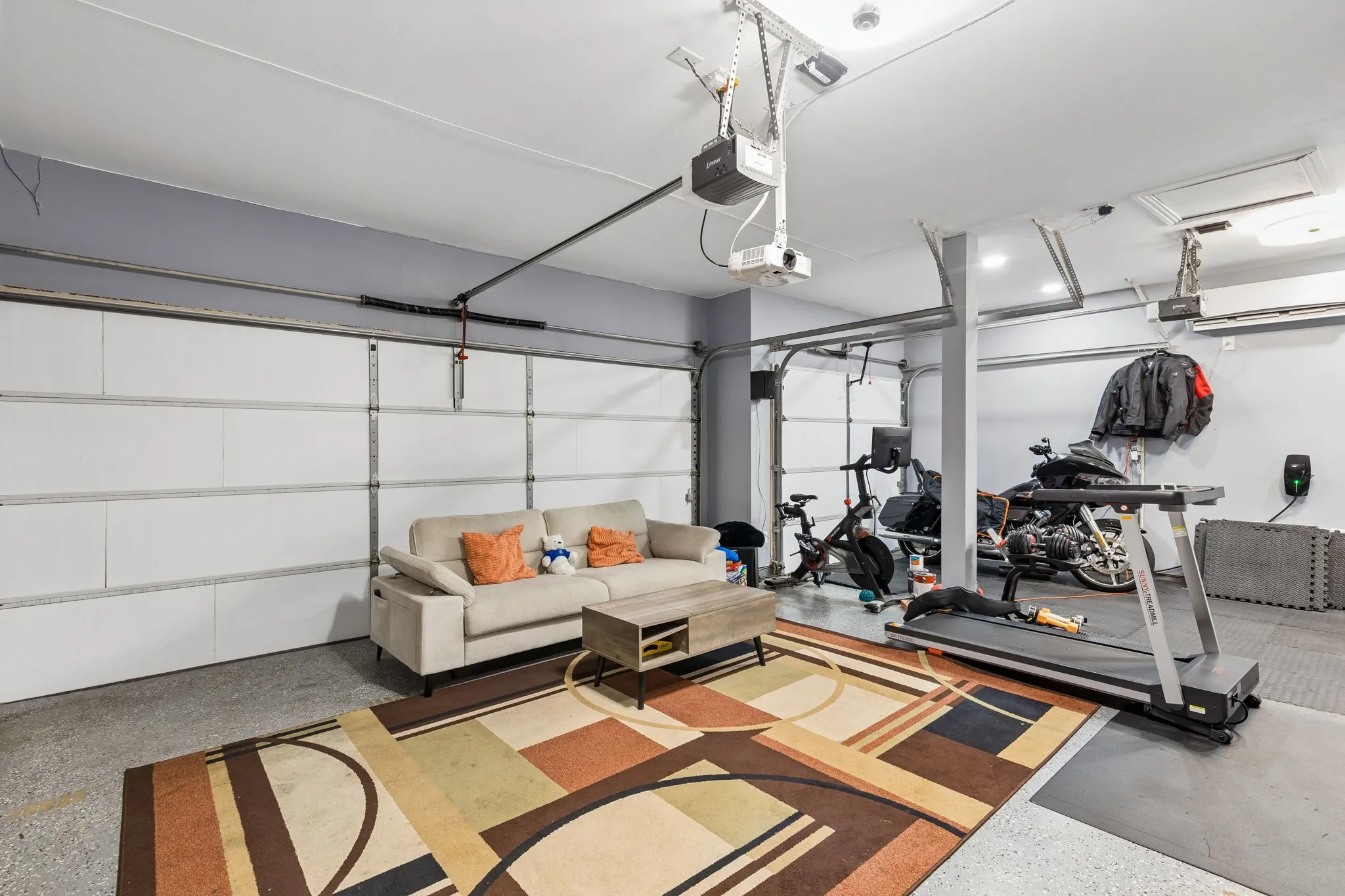 Attached garage featuring dual overhead doors and an exposed ceiling