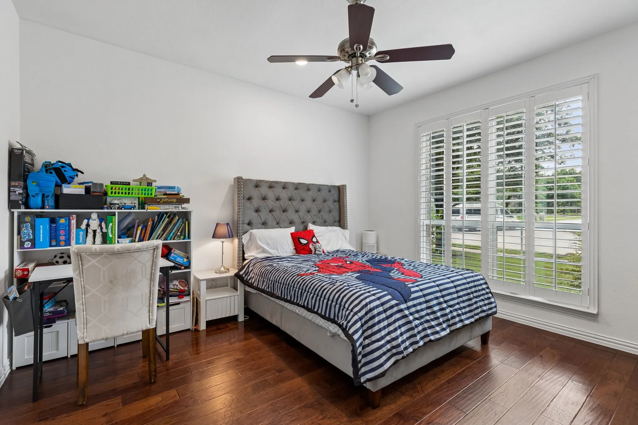 Hardwood-finish flooring, plantation shutters, white walls, and a ceiling fan with integrated lighting