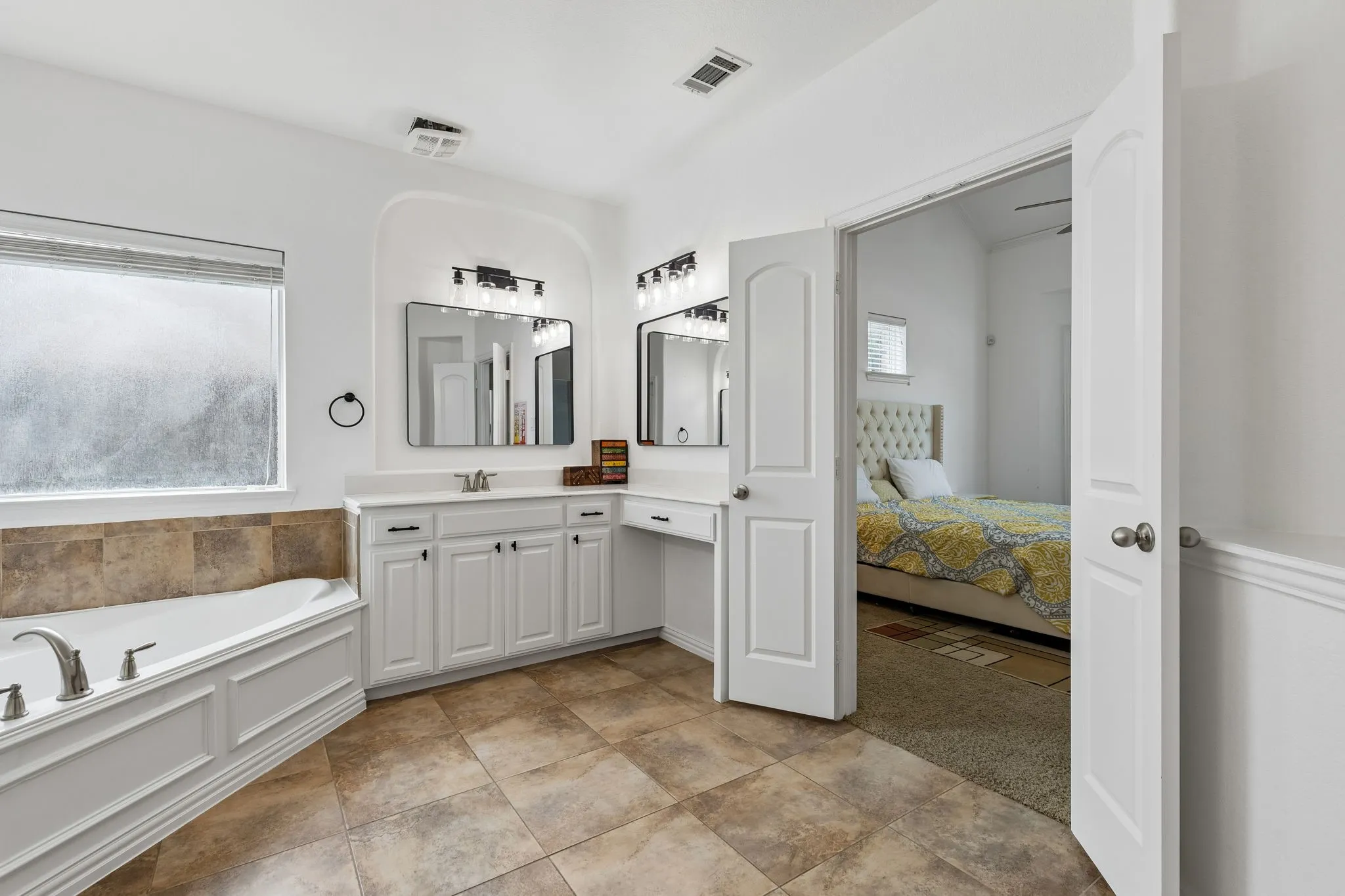 White double vanity with integrated makeup area, dual rectangular mirrors, and black-finish light fixtures