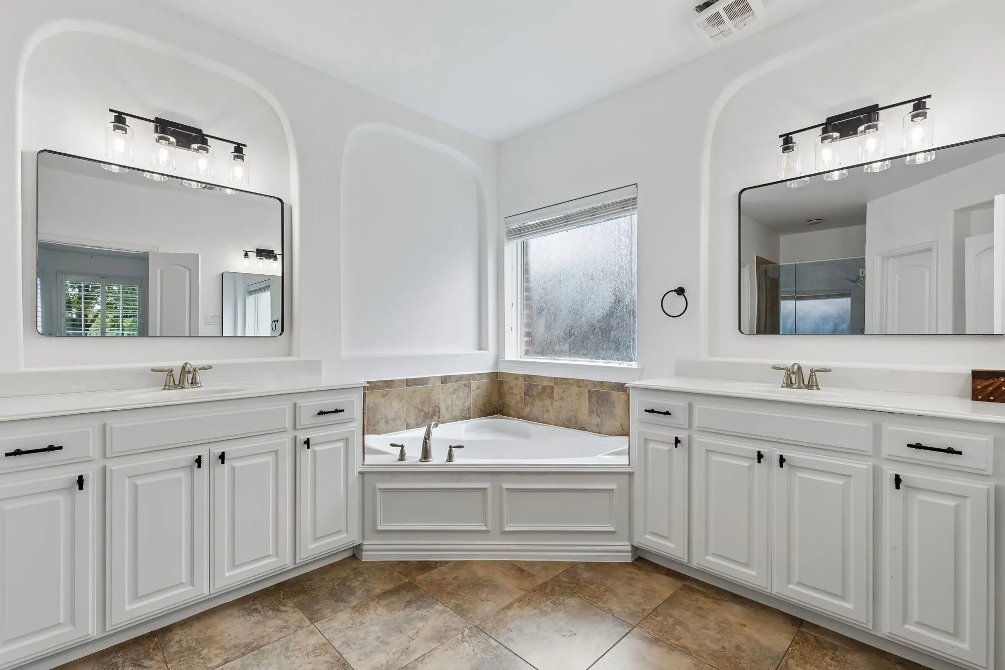 Dual vanities with white cabinetry, white countertops, and contemporary black-framed mirrors