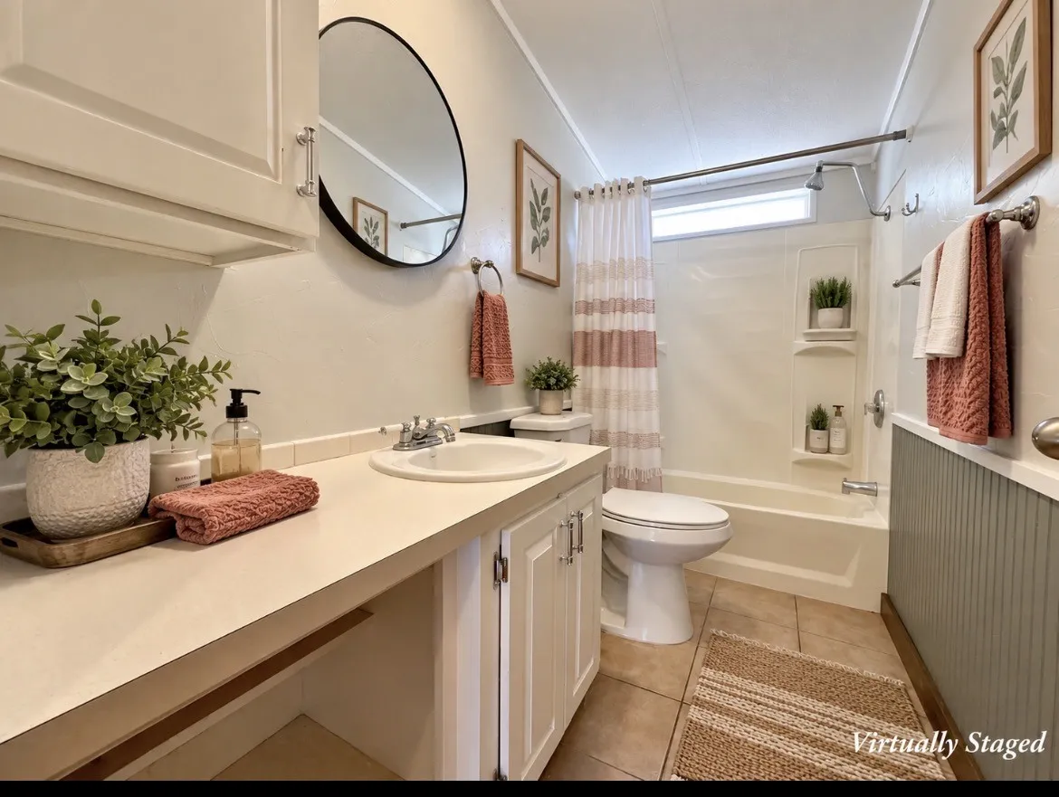 Bathroom featuring a white vanity with integrated sink, a white toilet, and a white tub with shower