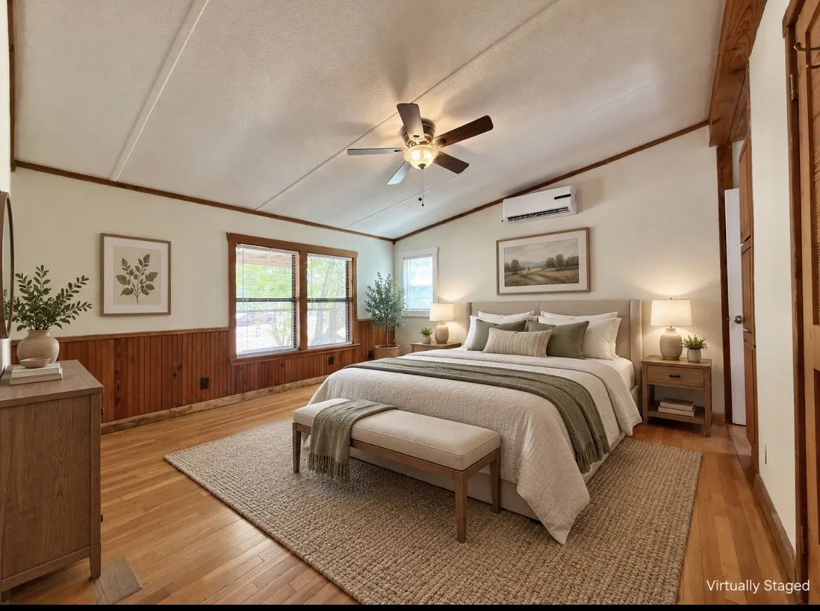 Vaulted ceiling, paneled accent wall, hardwood flooring, ceiling fan, and large windows