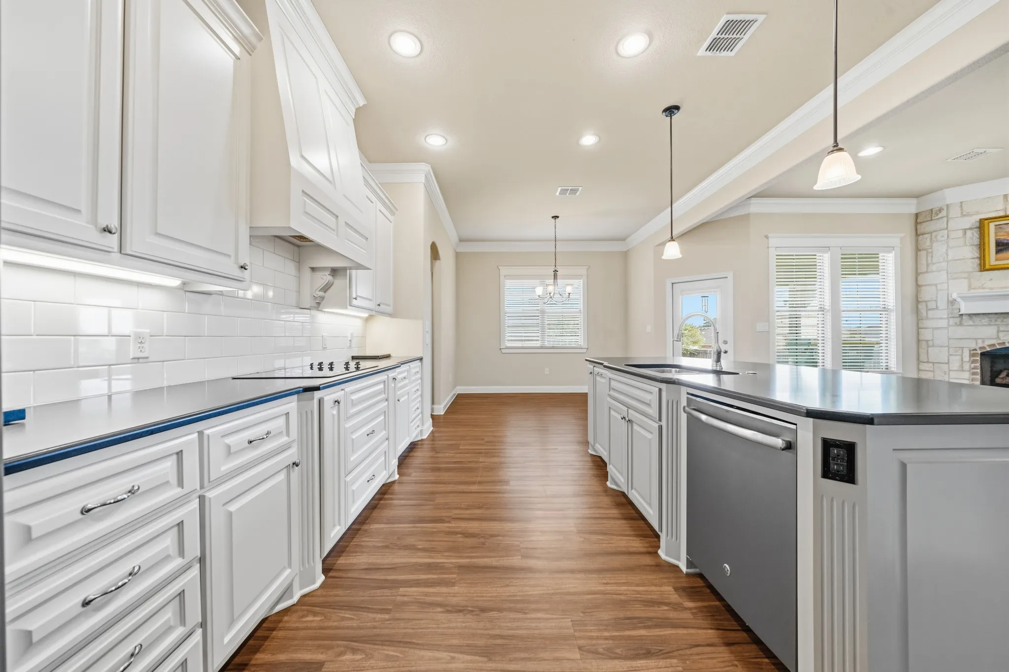 Kitchen with white cabinetry, crown molding, and, stainless steel appliances
