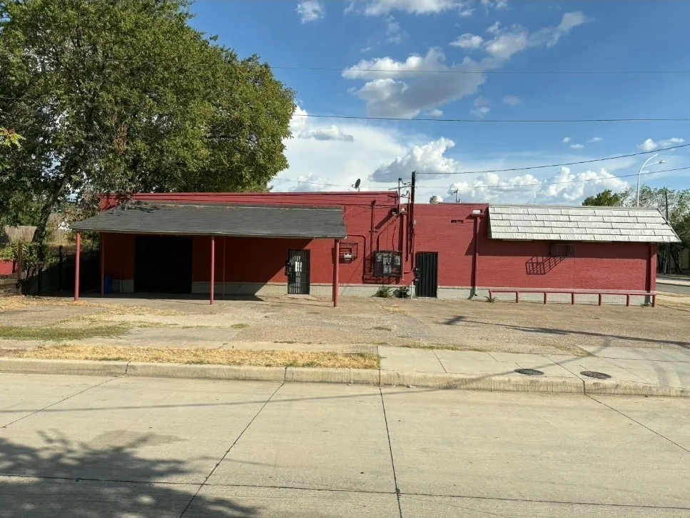 Red brick exterior with a flat roof section and an awning