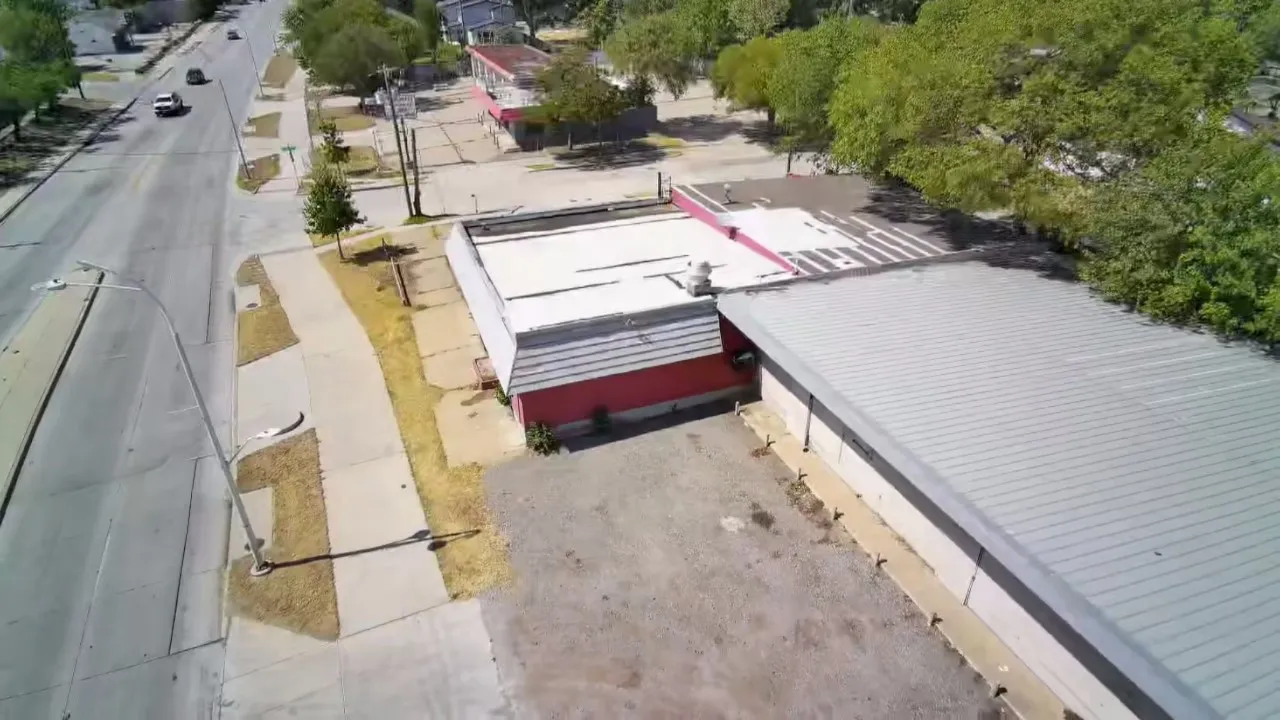 Commercial building with a flat roof, red siding, and an asphalt parking area