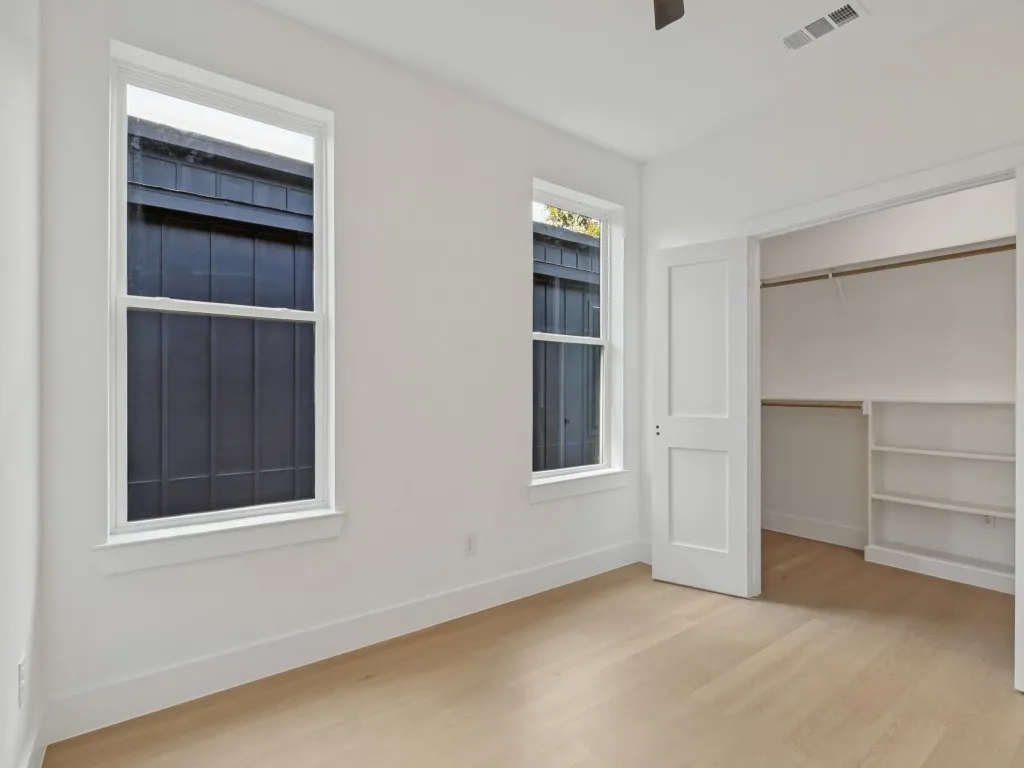 Light wood-finish flooring with white walls and trim