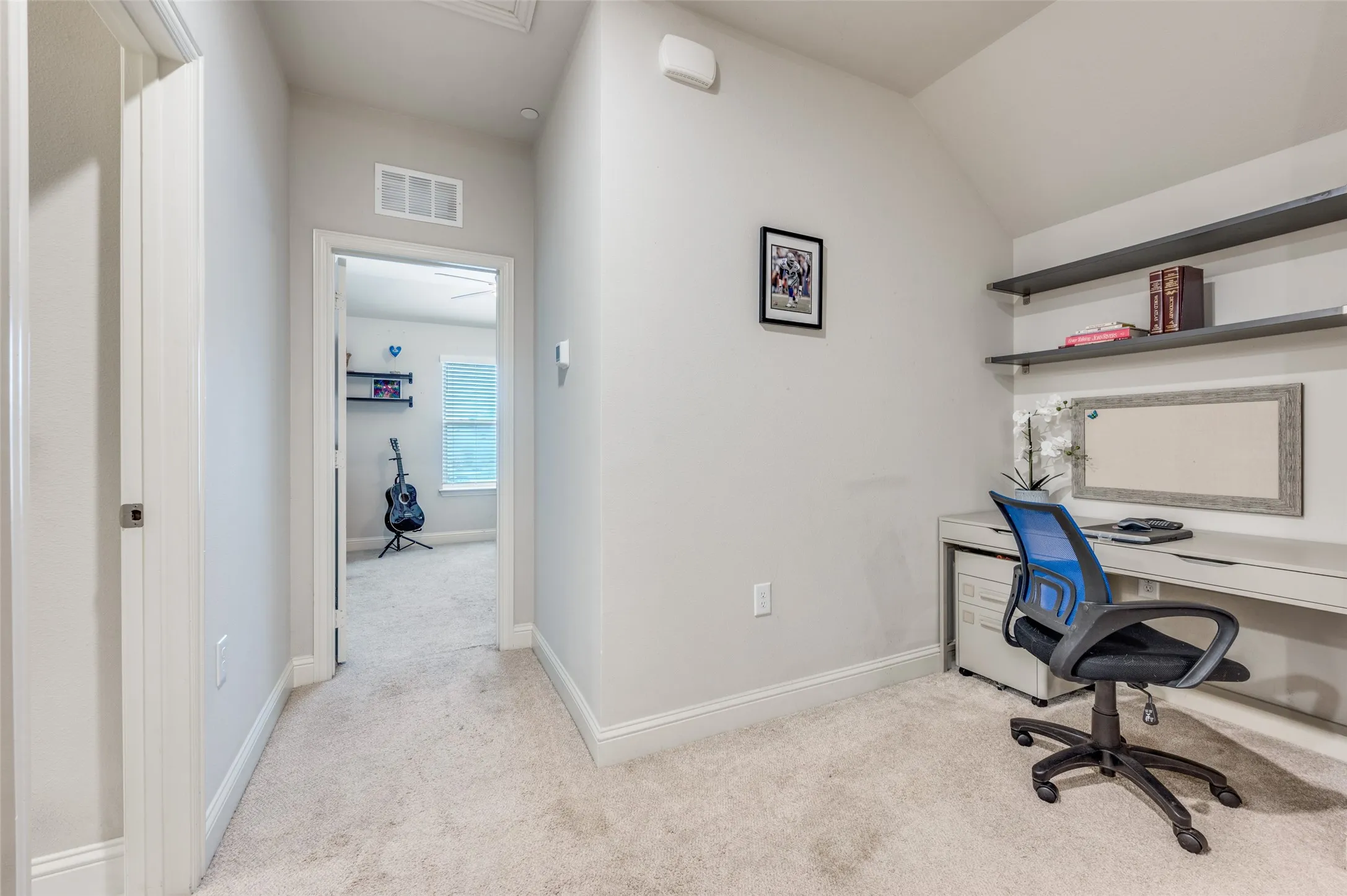 Built-in desk with integrated shelving and light-toned carpeting
