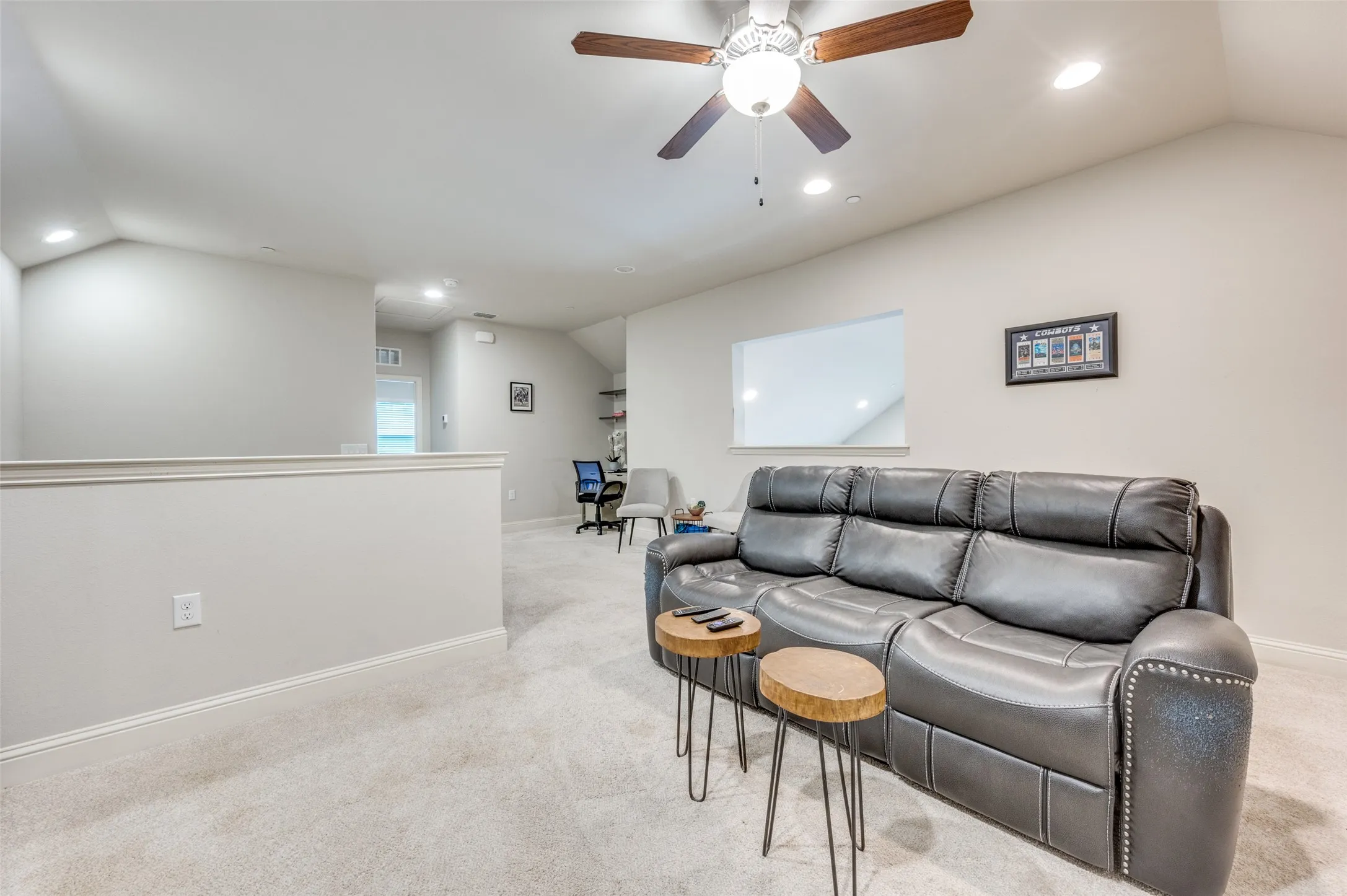 Carpeted loft space featuring a vaulted ceiling with a ceiling fan, recessed lighting, and a half-wall partition