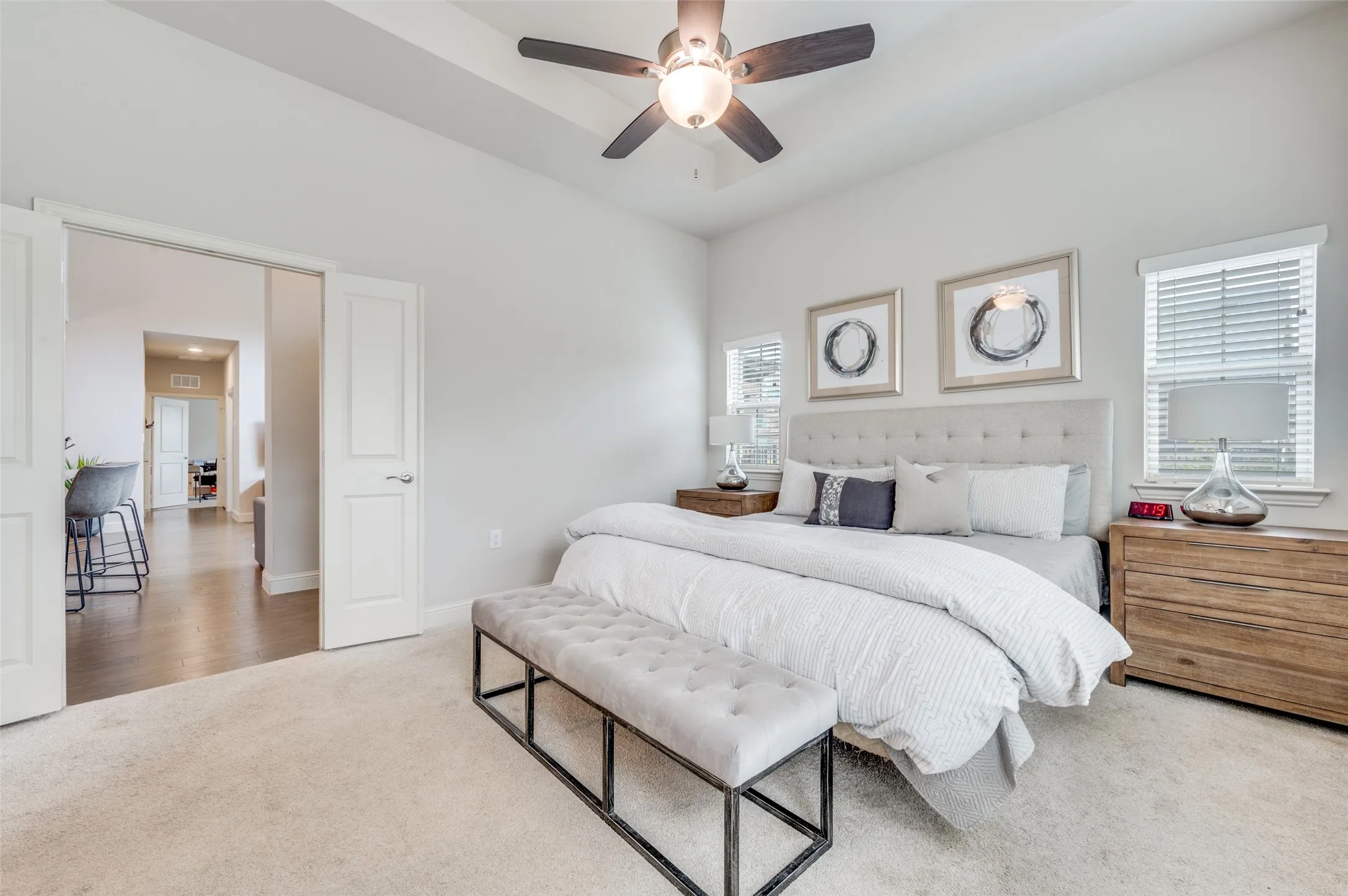 Plush carpeting, vaulted ceiling with a ceiling fan, dual windows with blinds, and white paneled doors