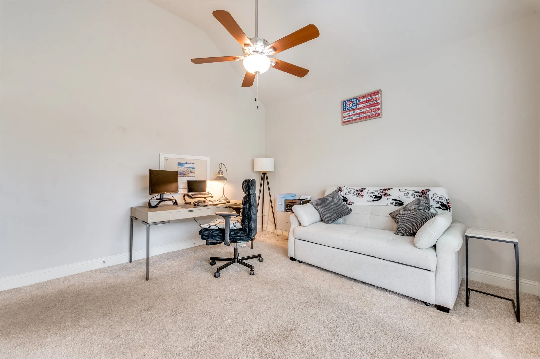 Vaulted ceiling with a ceiling fan, neutral wall paint, and carpet flooring