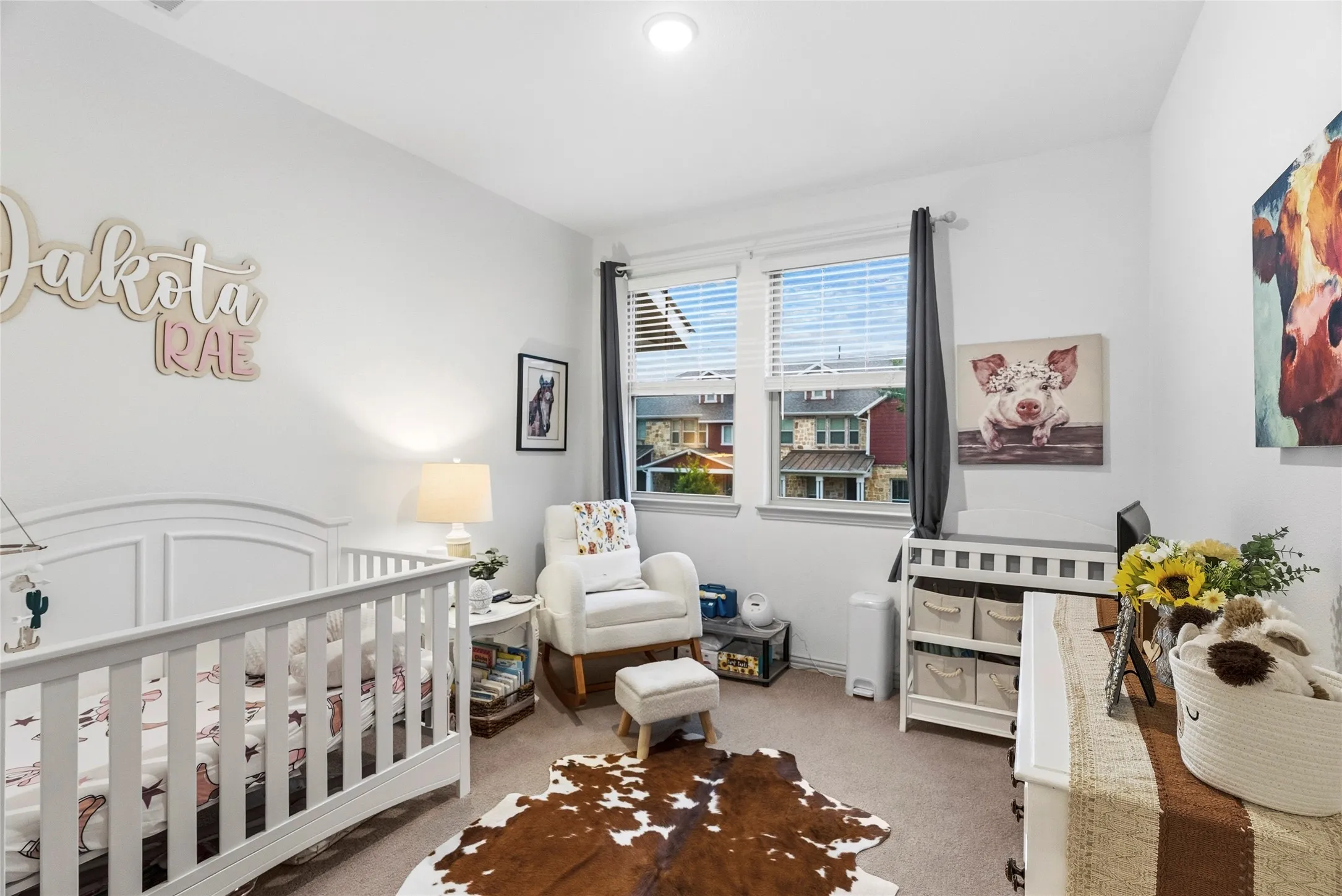 Bright room with neutral wall paint, two windows with blinds, a ceiling light fixture, and carpet flooring