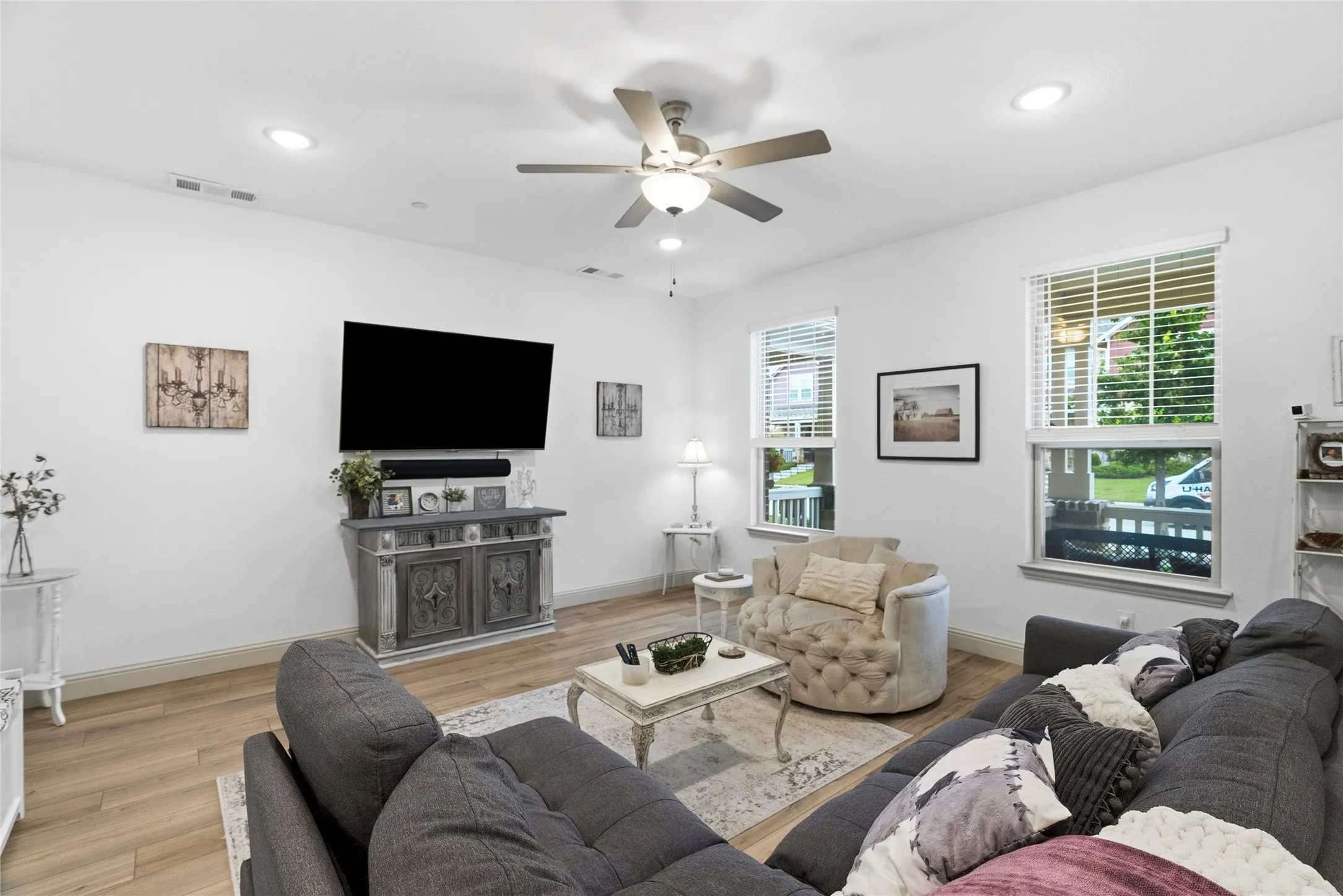 Recessed lighting, wood-finish flooring, ceiling fan, and multiple windows with blinds