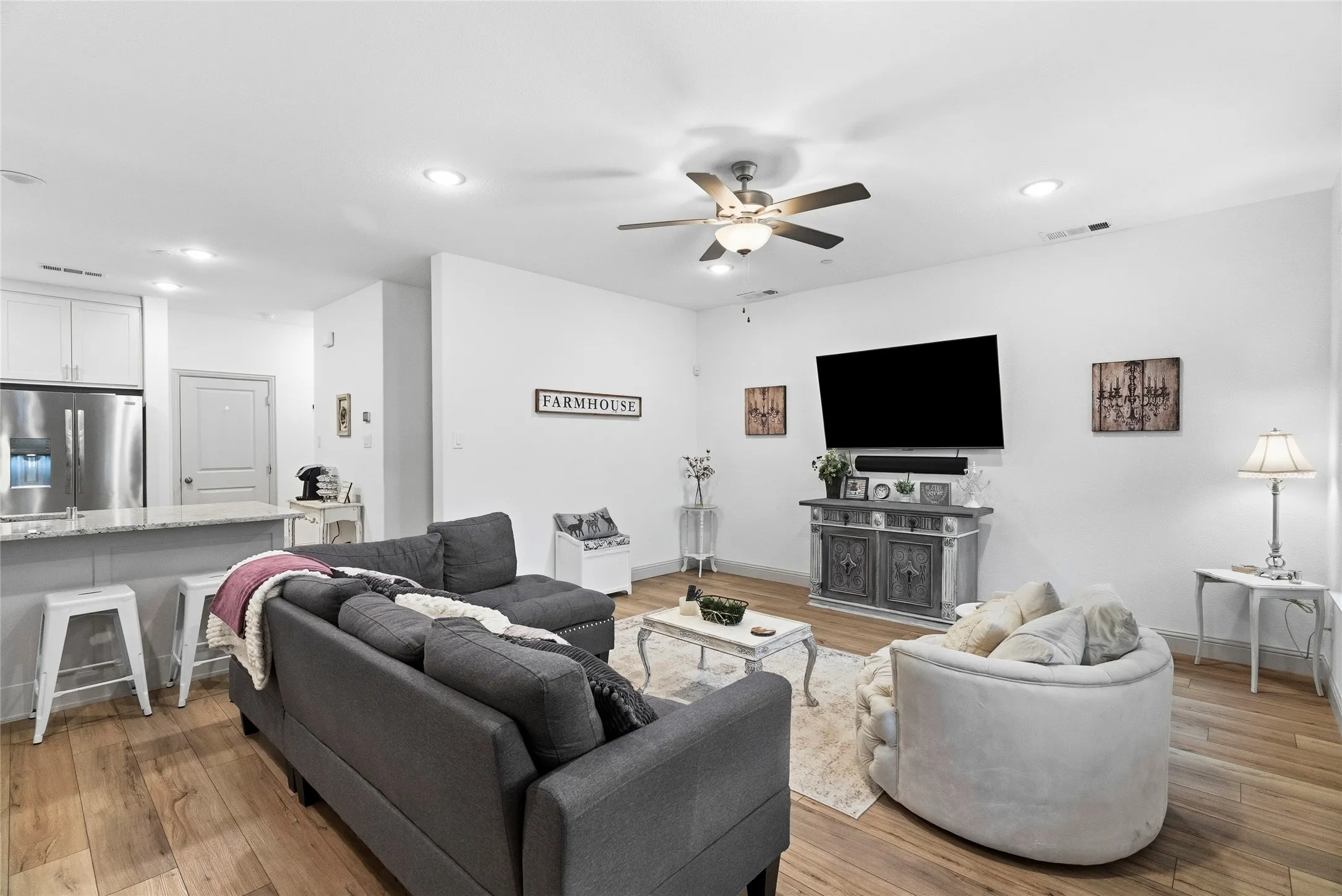 Open-concept living space with wood-finish flooring, recessed lighting, and a ceiling fan