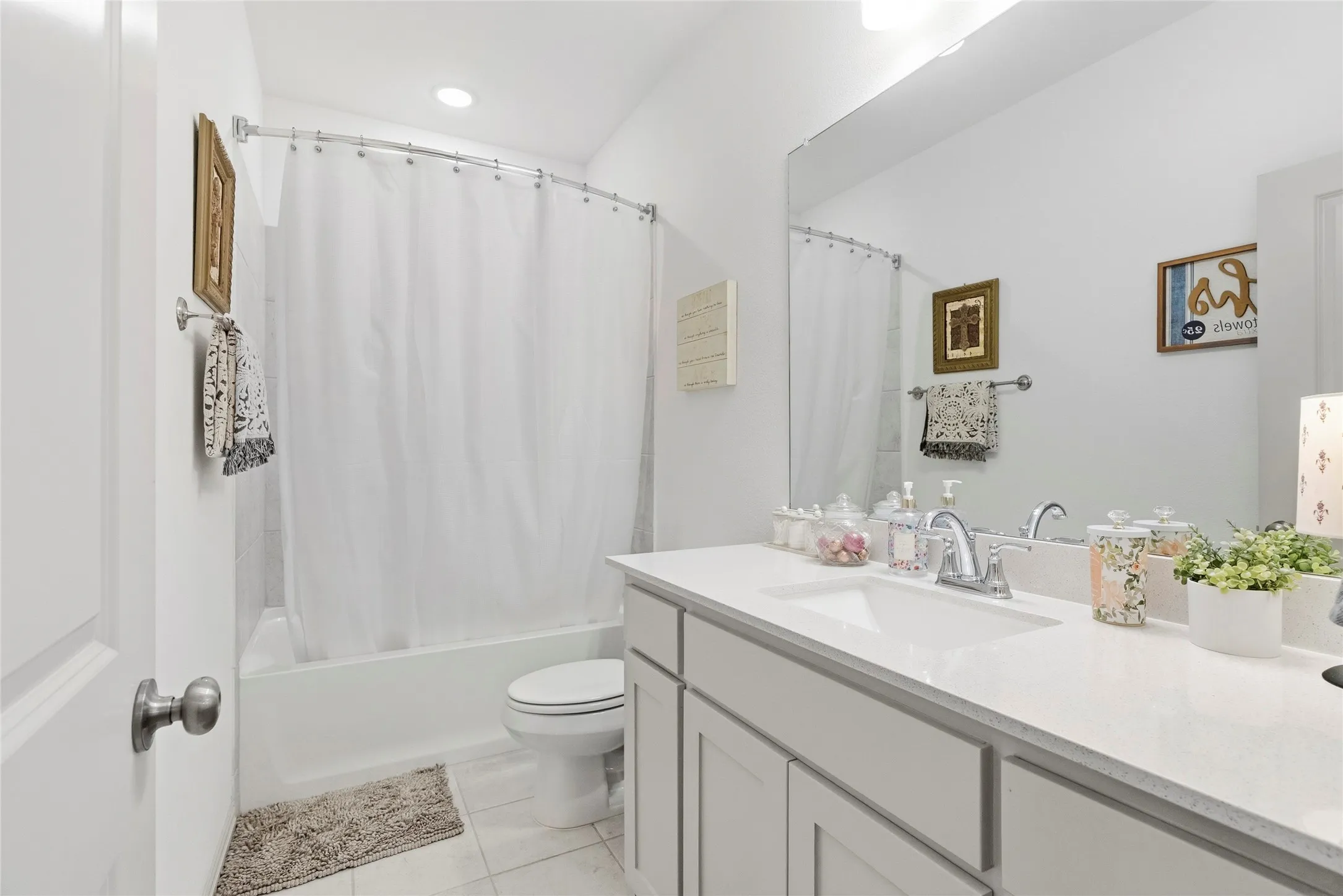 Bathroom featuring a single vanity with an integrated sink, polished chrome faucet, gray shaker-style cabinetry, and a full-width mirror