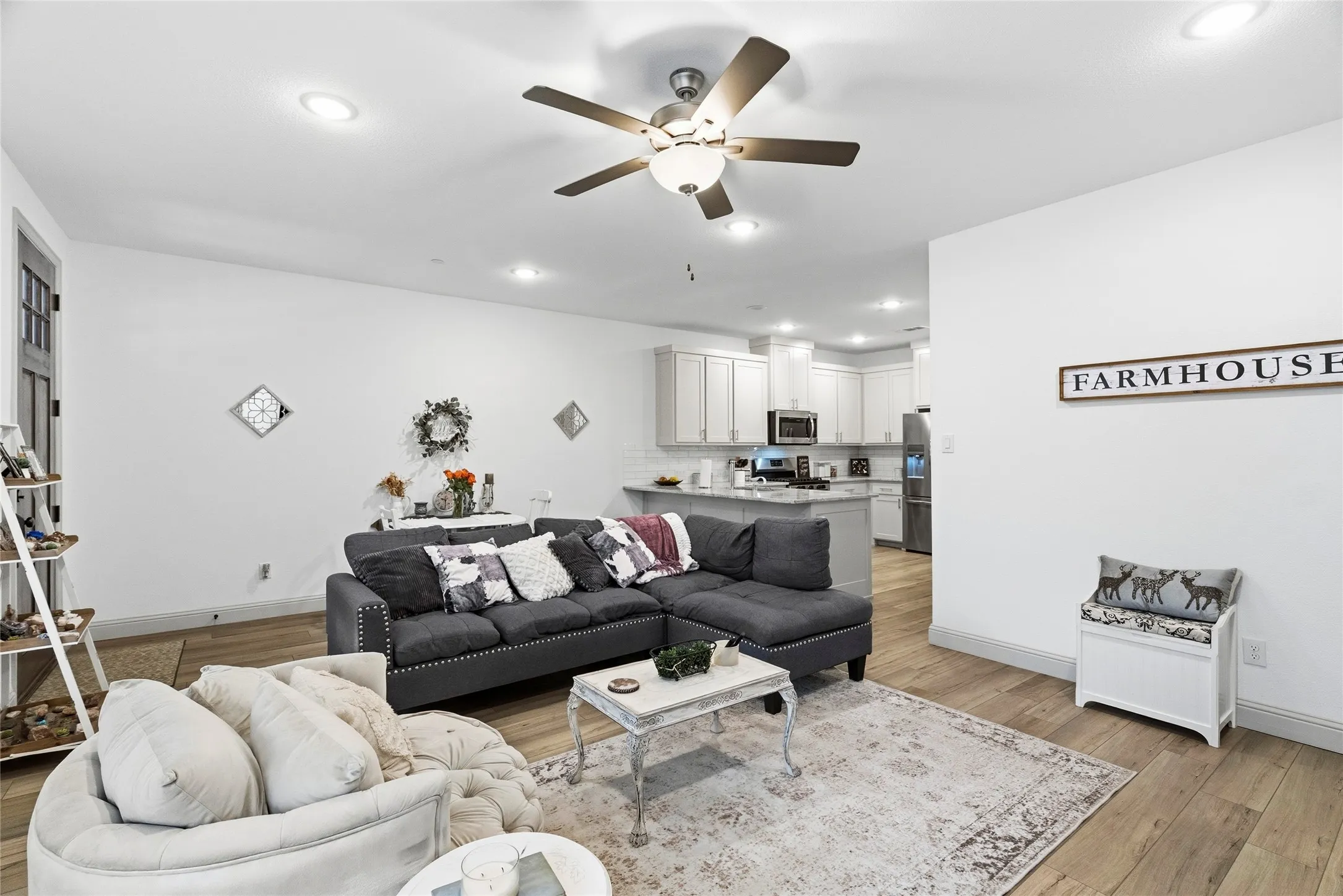 Open-concept living area with wood-finish flooring, recessed lighting, and a ceiling fan