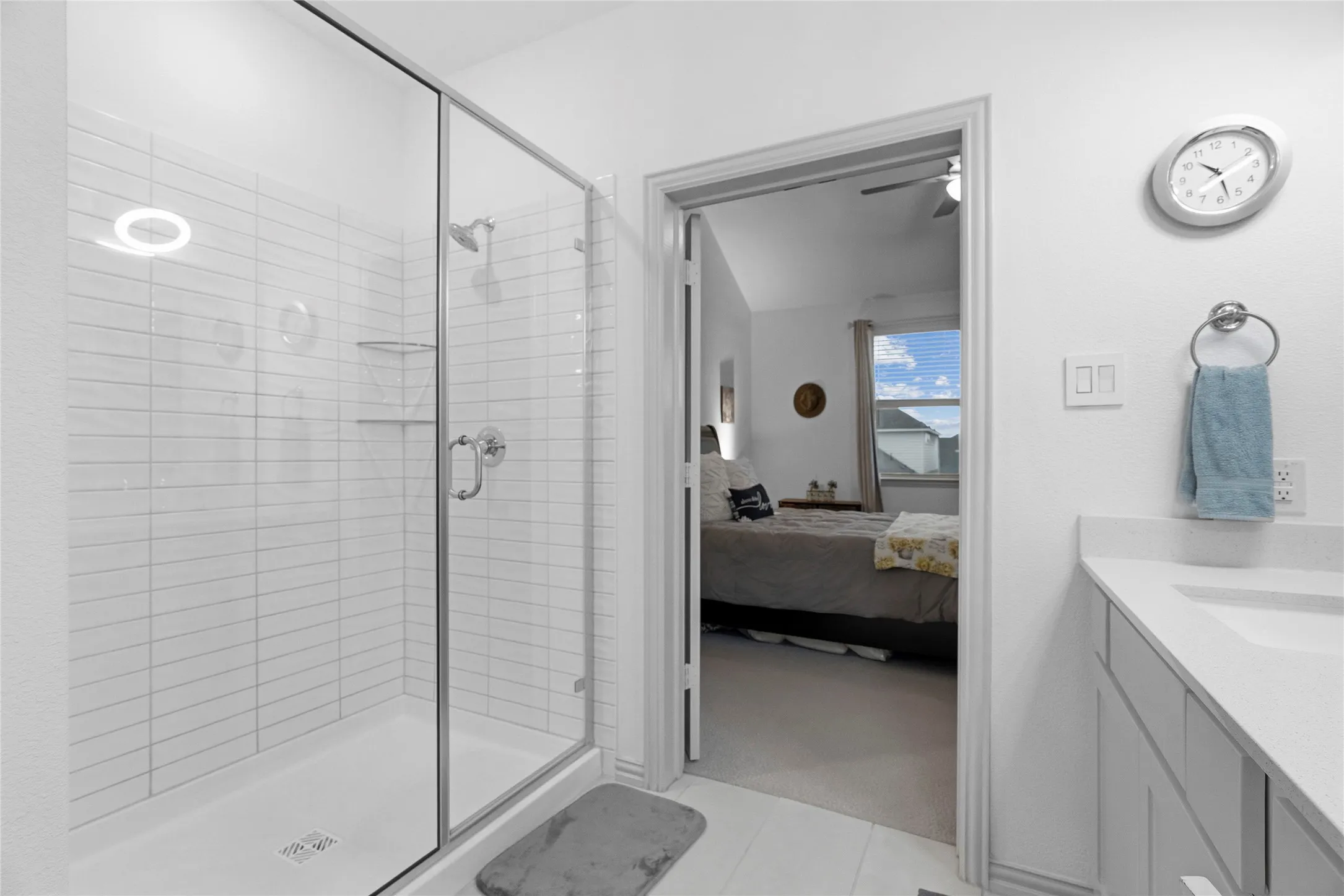 Glass-enclosed shower with subway tile surround, polished chrome fixtures, and a shower niche