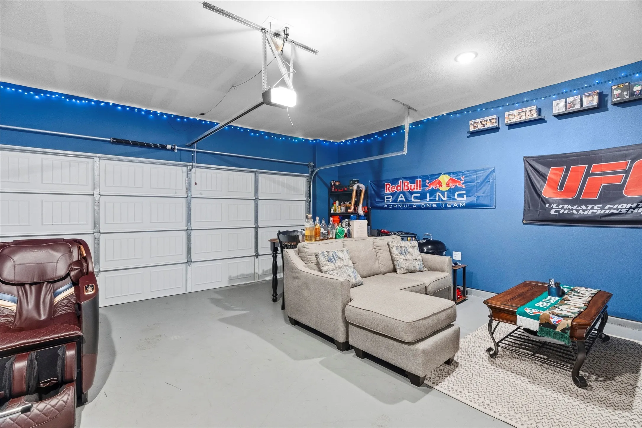 Garage space featuring a painted concrete floor and overhead lighting