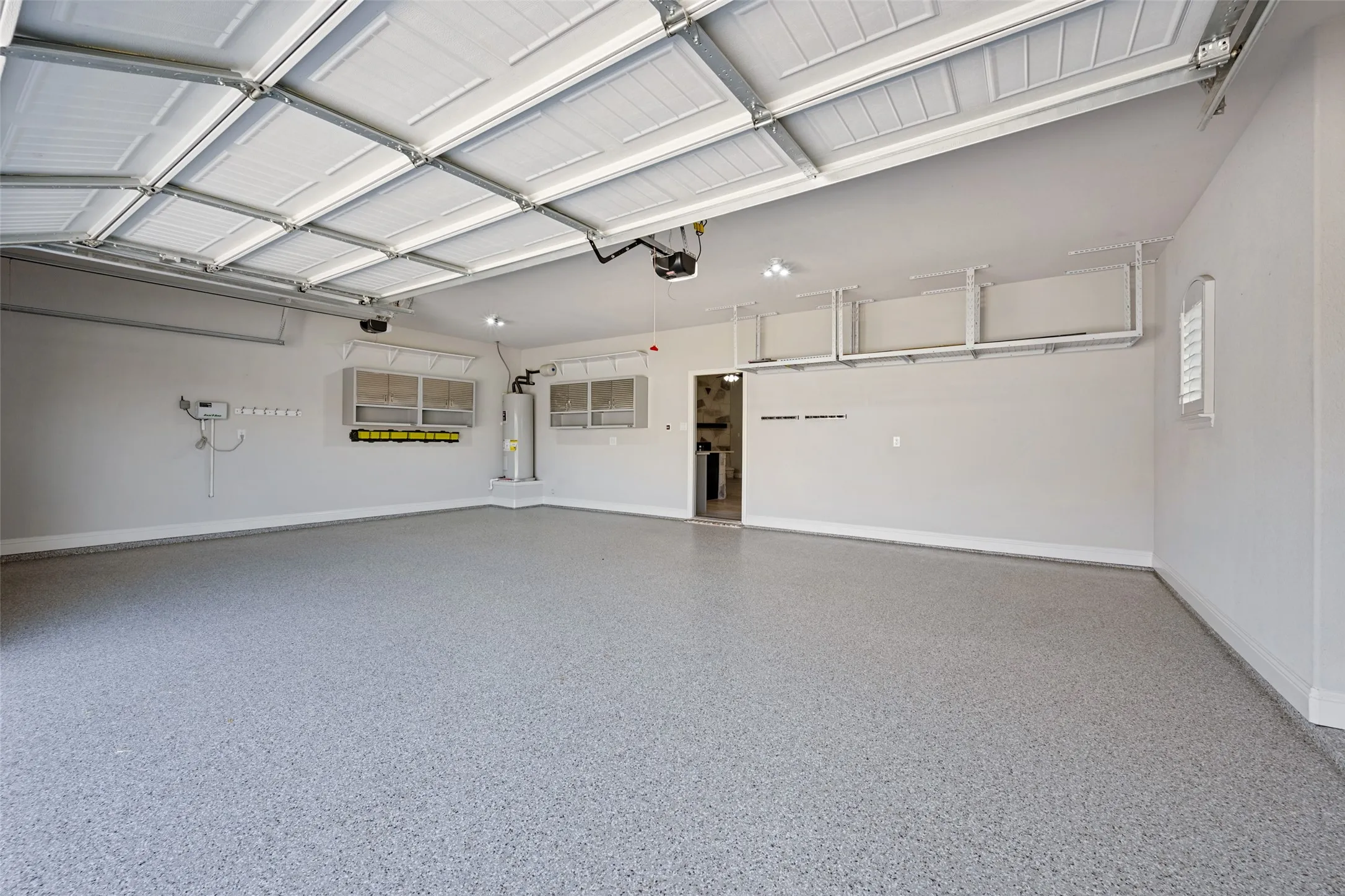 A beautiful epoxy-coated floor, overhead storage racks, and multiple windows shout first-class in this 3-car garage.