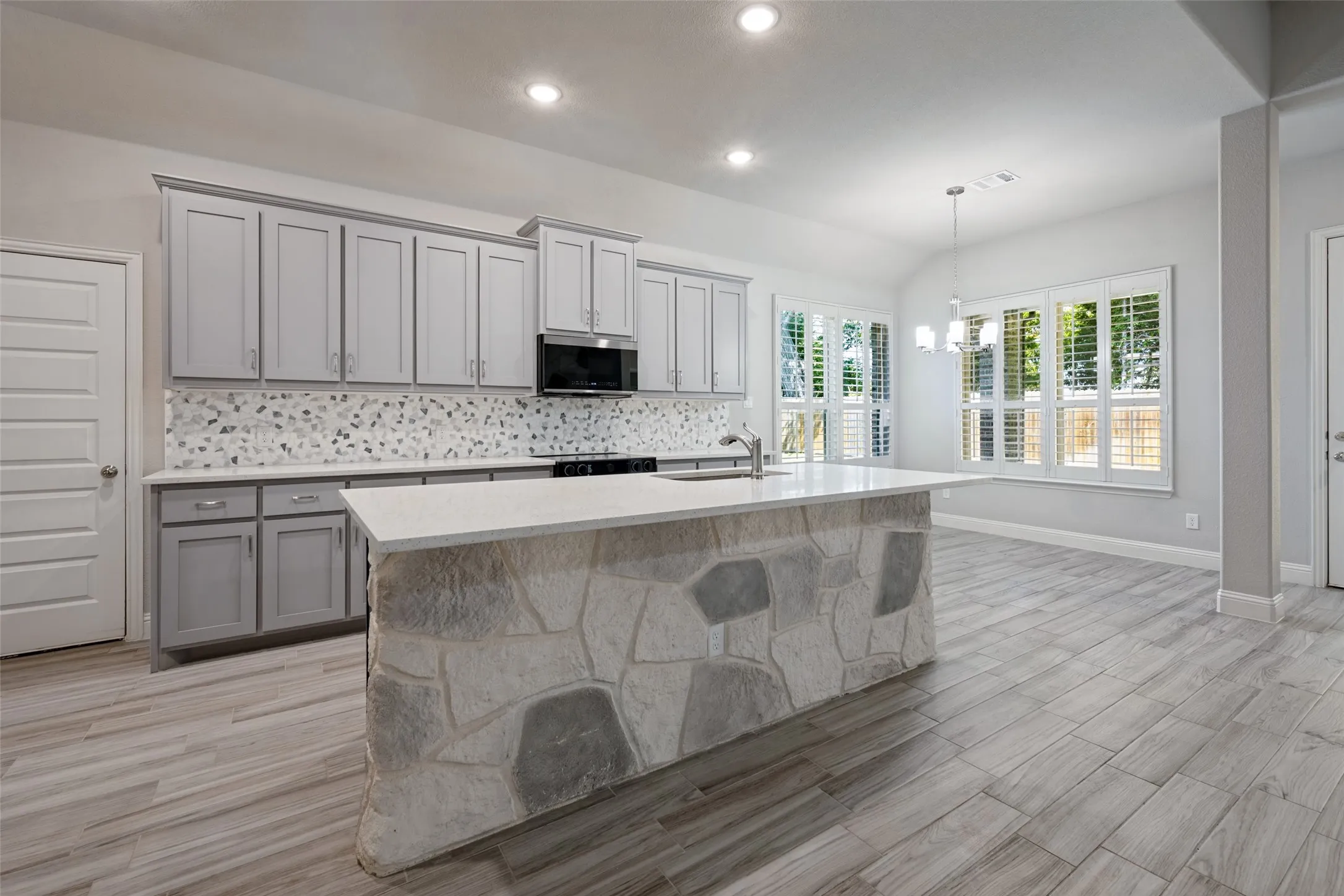 The kitchen opens to the living area and the breakfast nook. The windows are adorned with plantation shutters and open to the backyard.