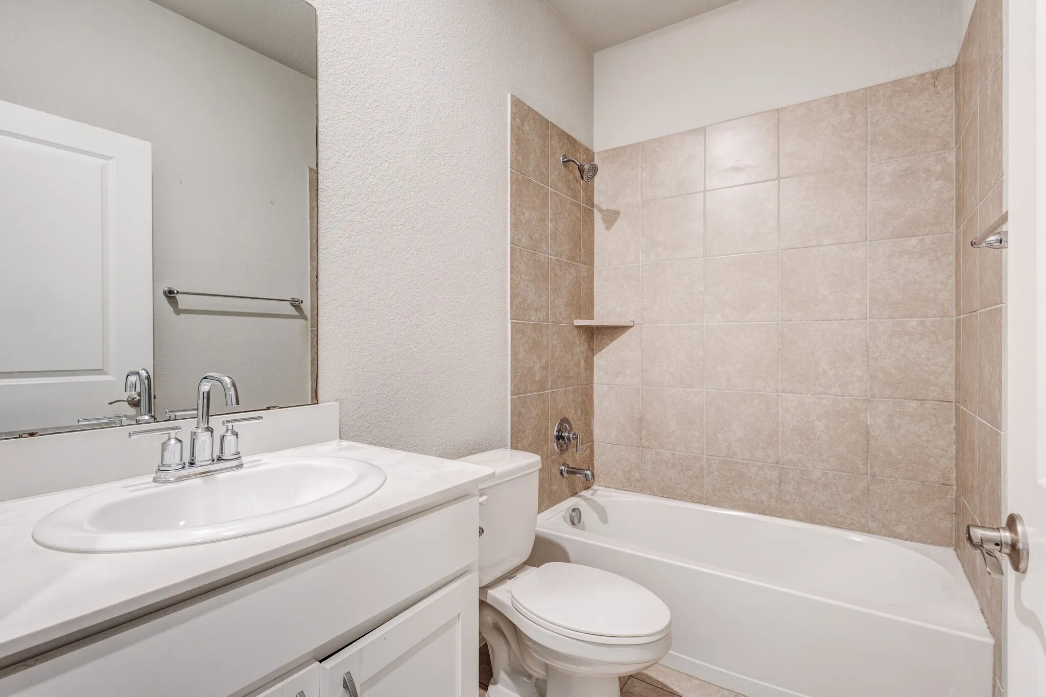 White cabinetry with chrome hardware, an integrated oval sink, and a chrome faucet