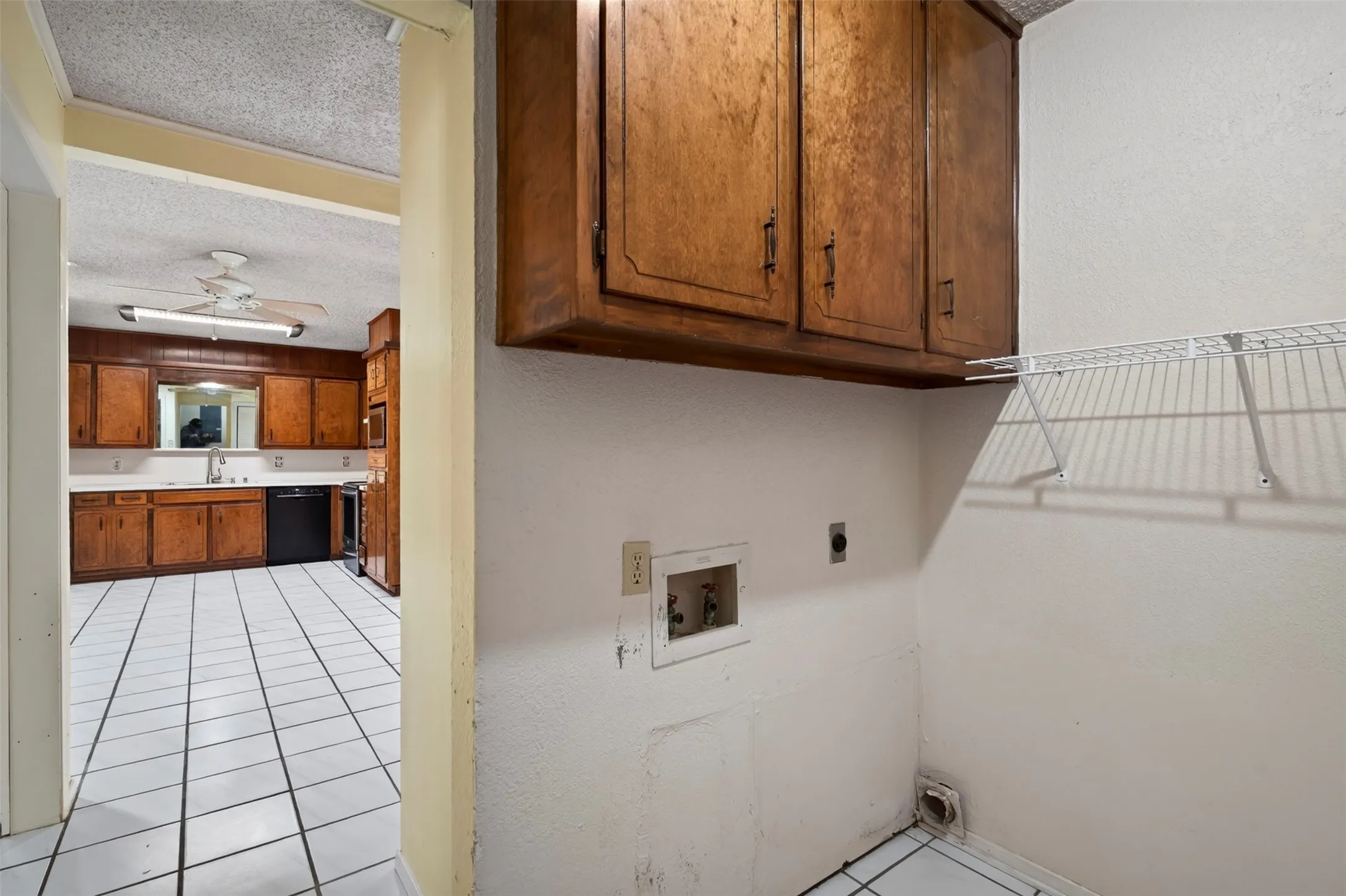 Laundry area with overhead cabinetry and wire shelving