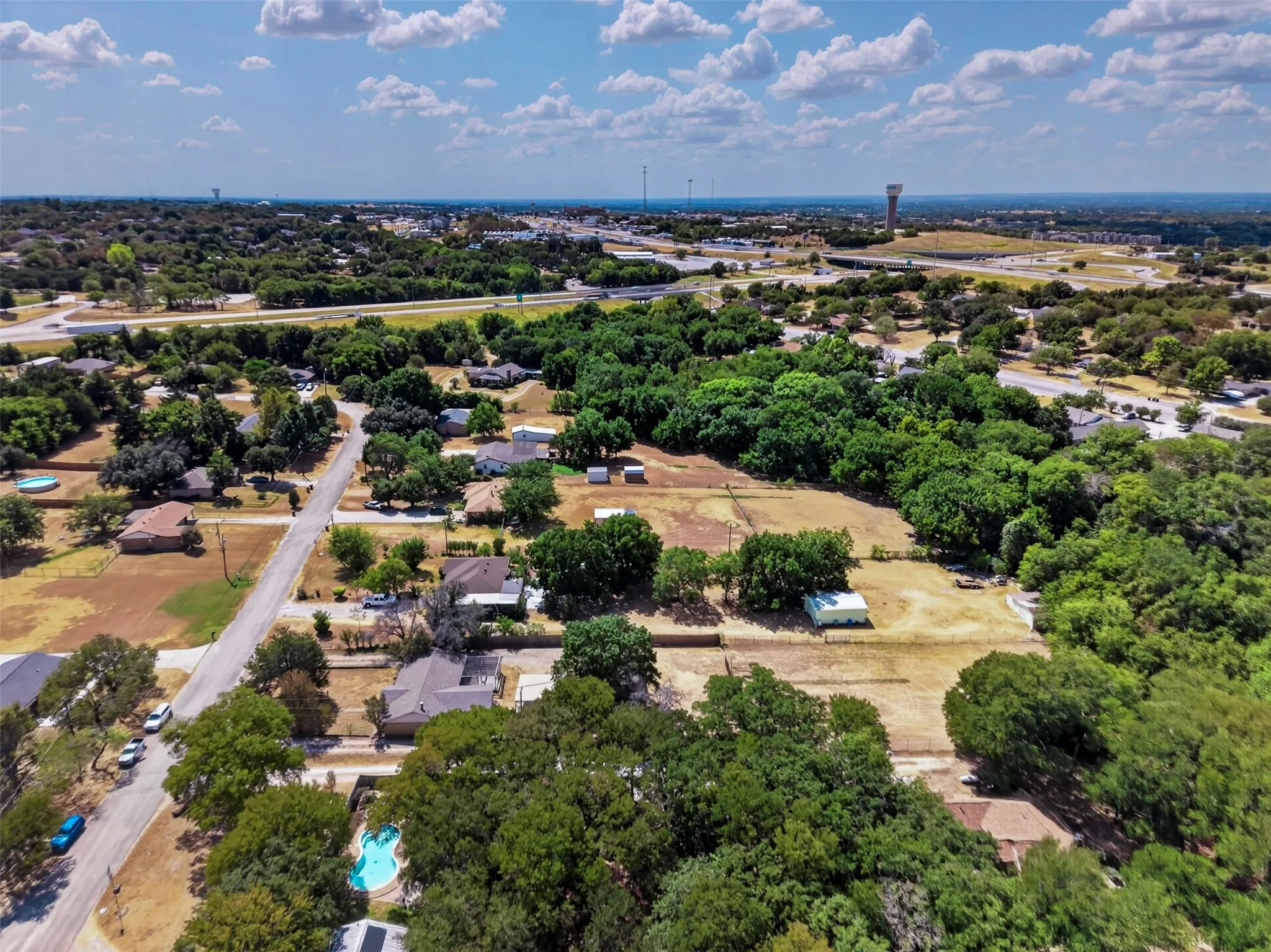 Aerial perspective showcasing residential properties amidst mature trees and clear skies