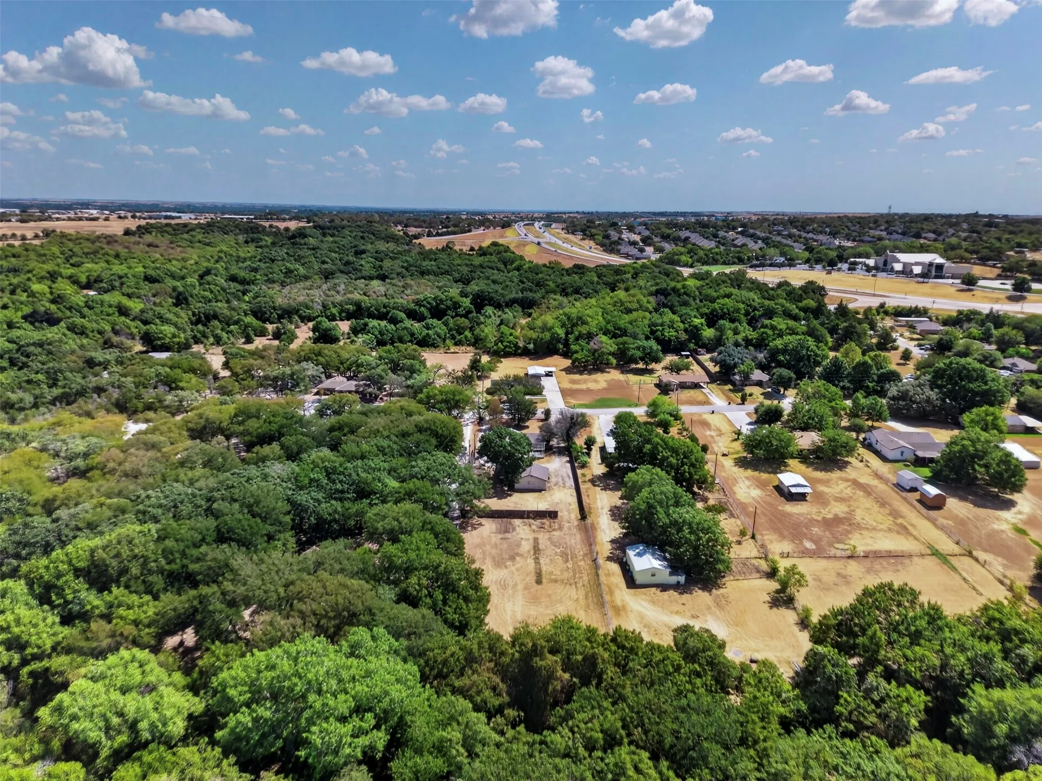 Expansive natural landscape featuring lush tree coverage and surrounding residential properties