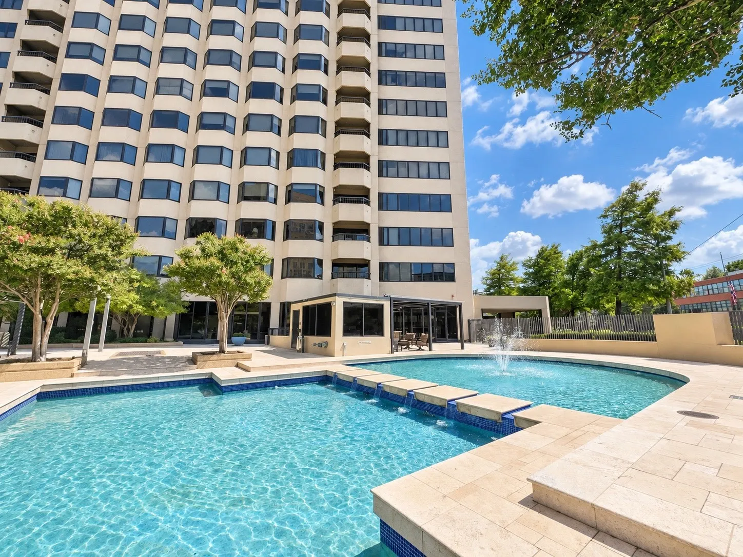 Exterior facade featuring multiple bay windows, an expansive swimming pool with a fountain, and a connecting footbridge