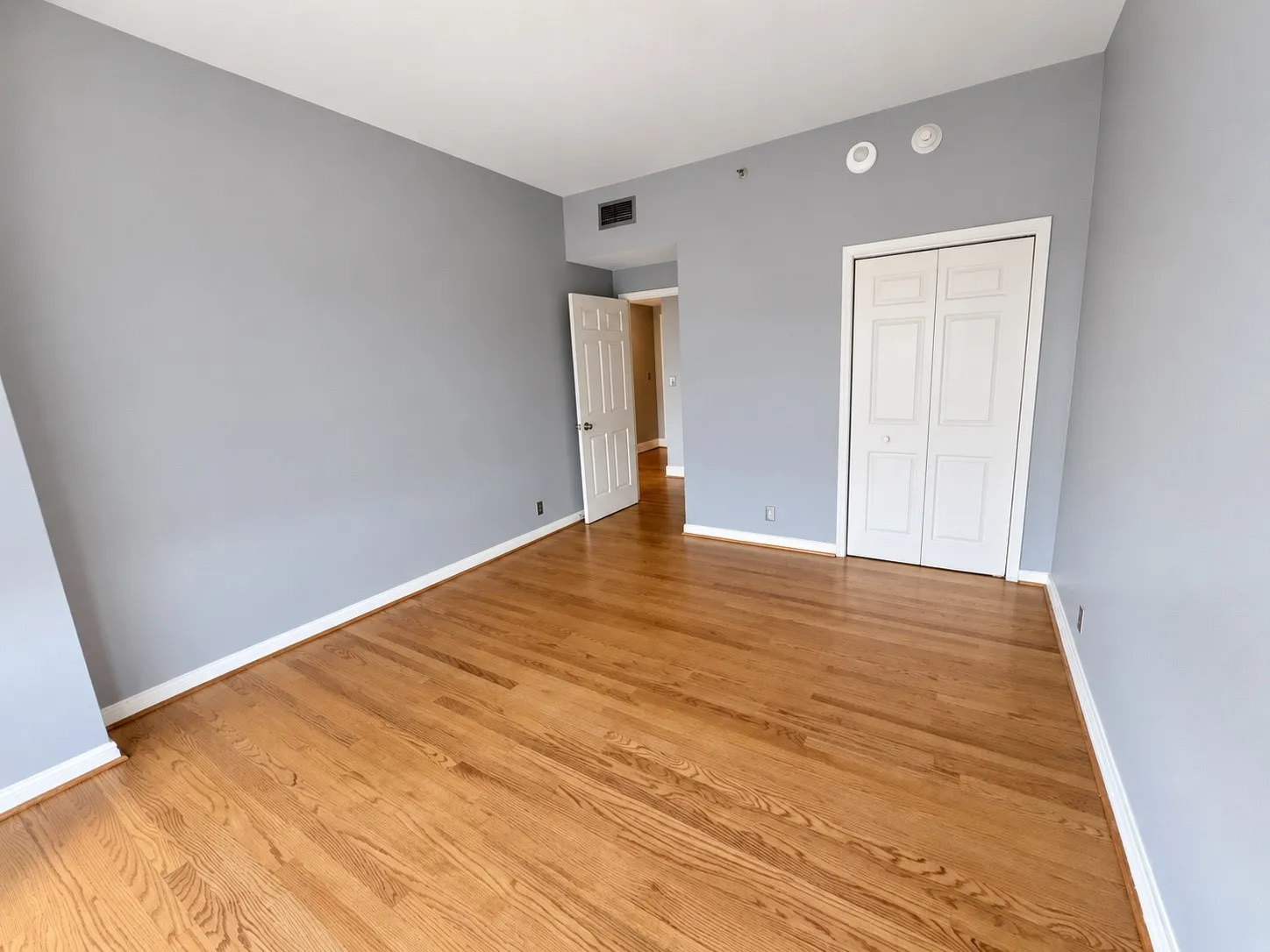 Hardwood flooring, painted walls, built-in closet with bi-fold doors, and recessed lighting