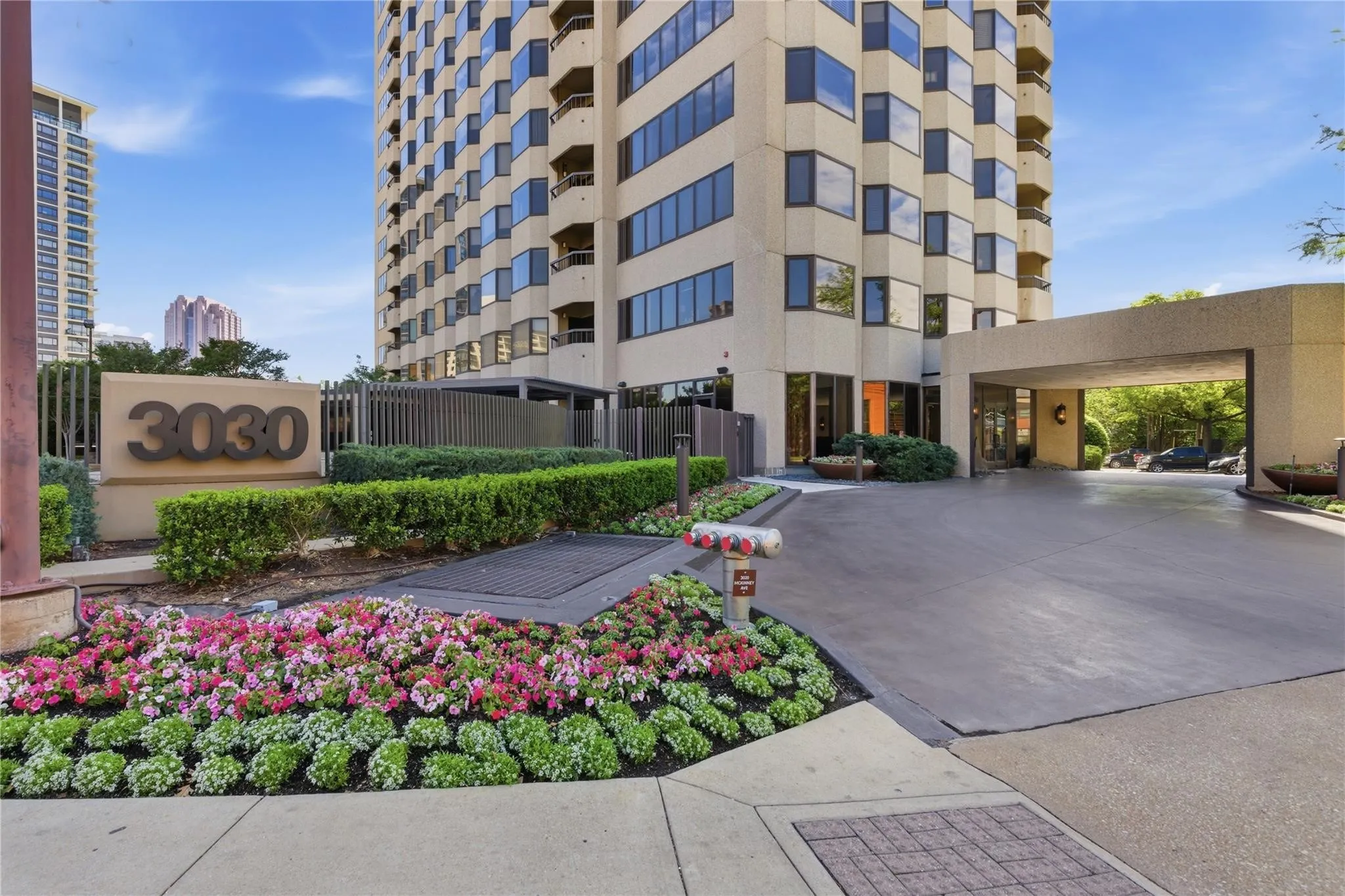 High-rise building with a porte-cochère entrance, expansive windows, and multiple balconies