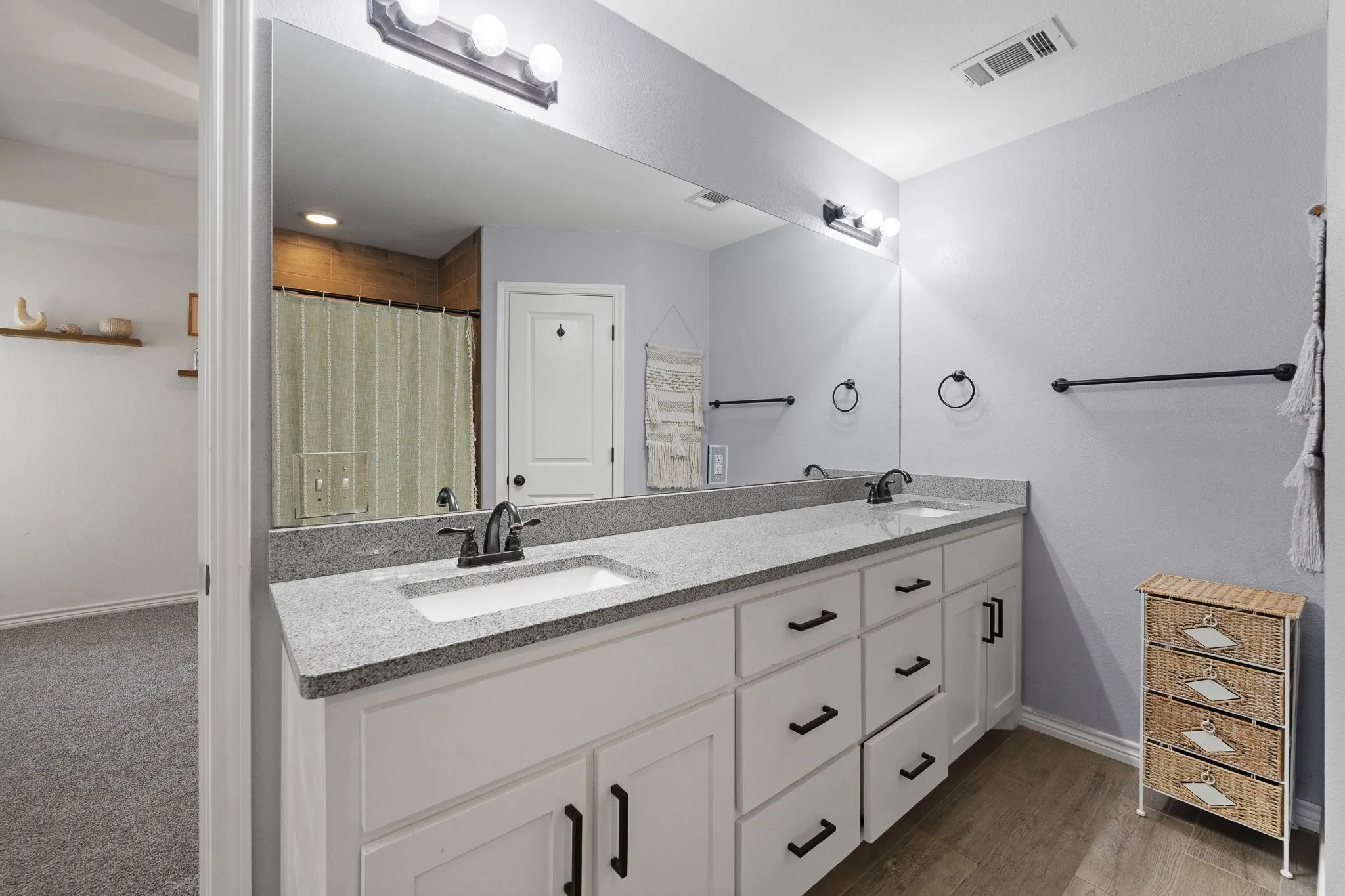 Dual vanity with granite-style countertop, undermount sinks, and matte black fixtures