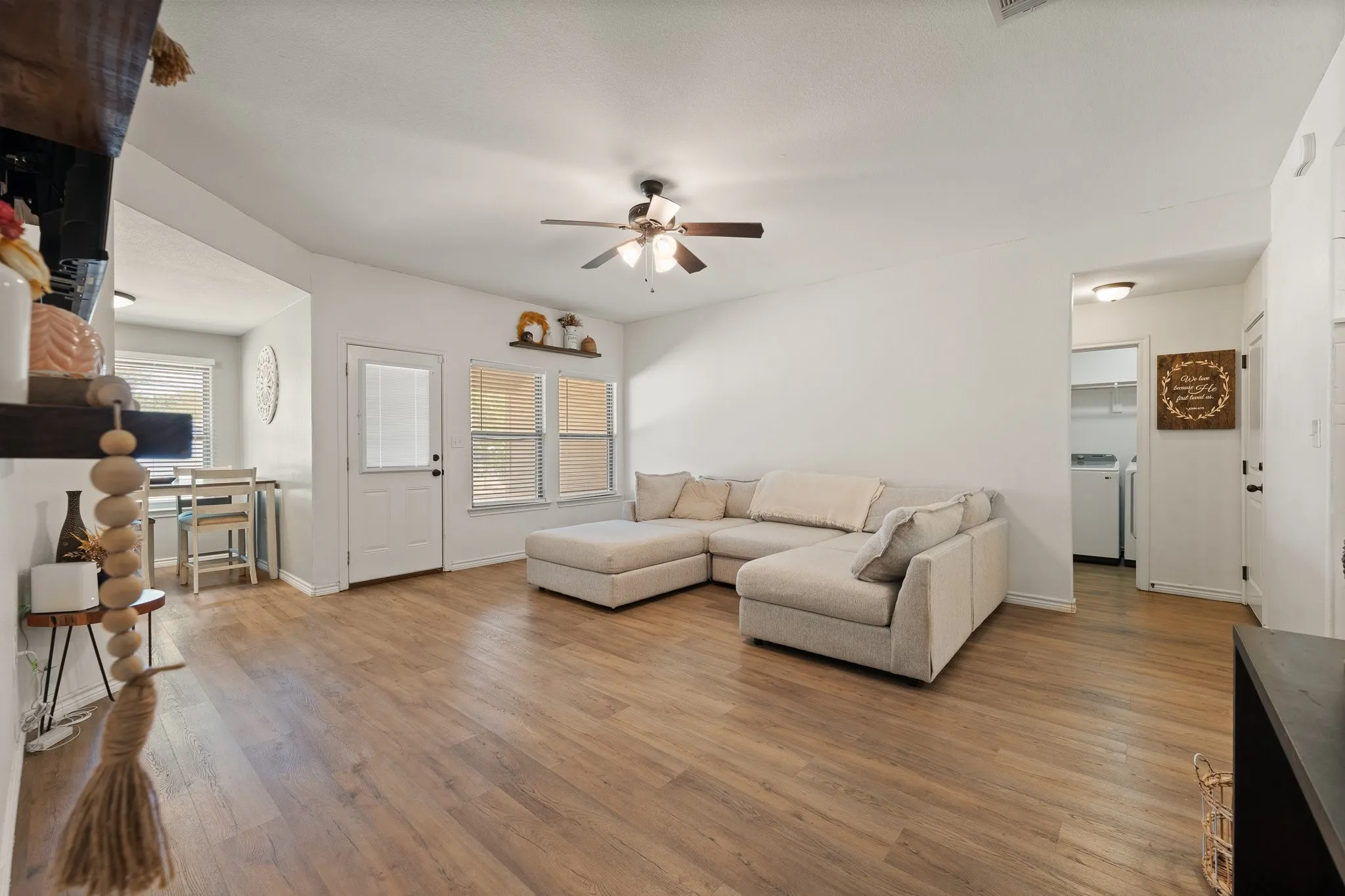 Spacious living area featuring wood-finish flooring and a ceiling fan