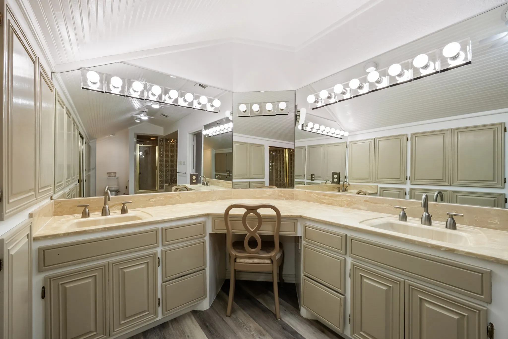 Dual vanity with integrated sinks, expansive counter space, ample cabinetry, and task lighting