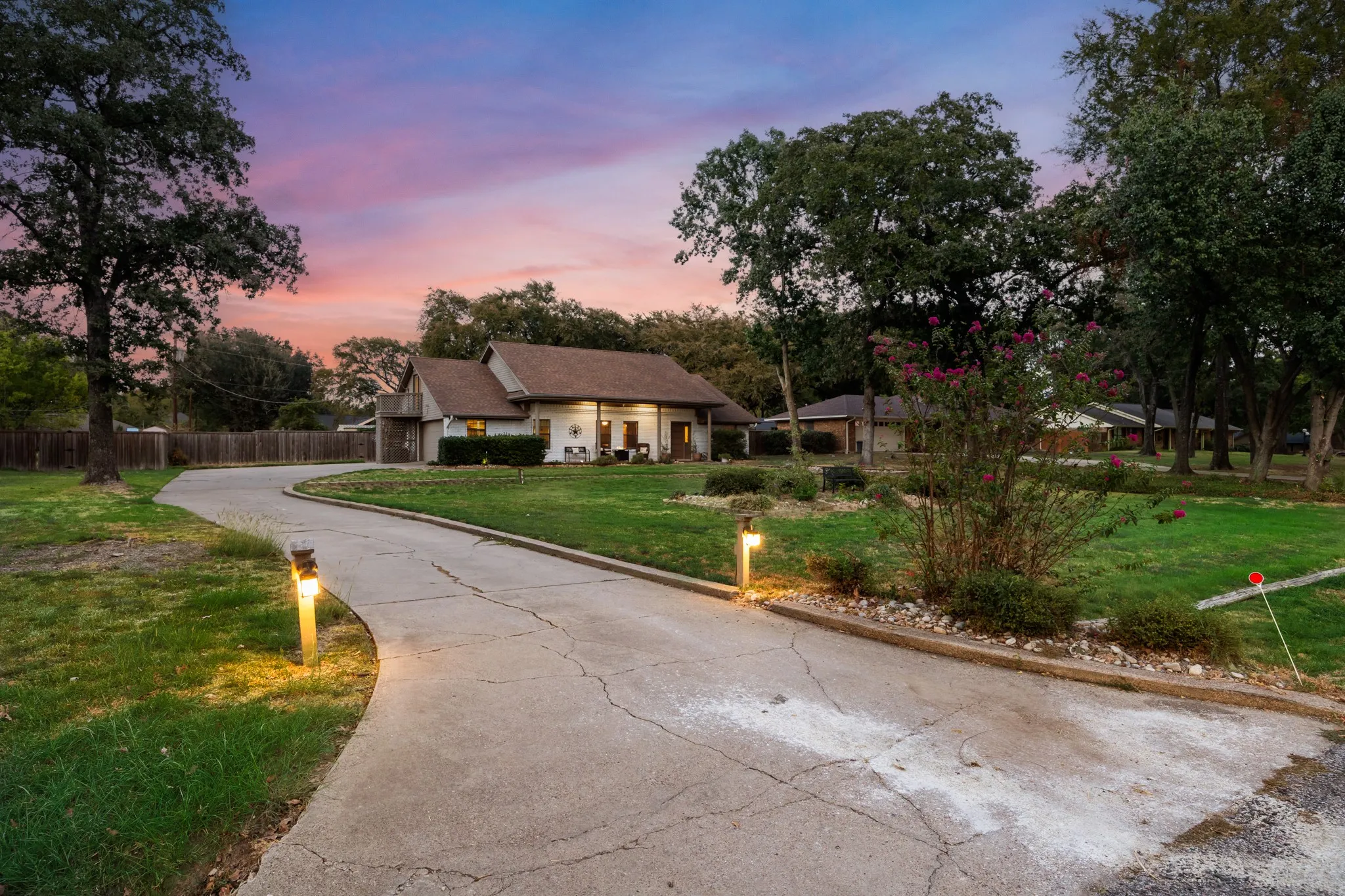 Curved concrete driveway with accent lighting