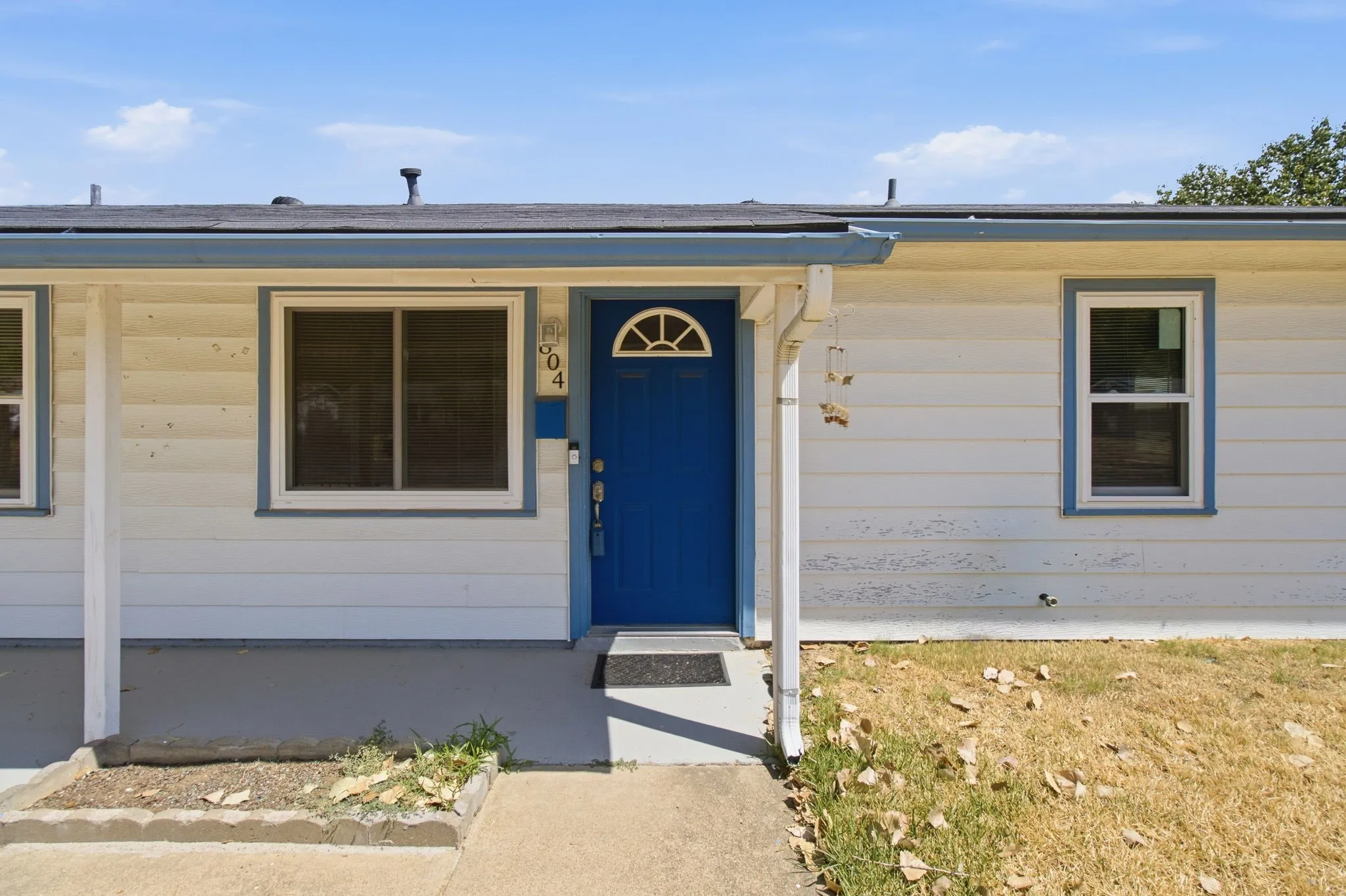 Entry with a vibrant blue door featuring an arched window