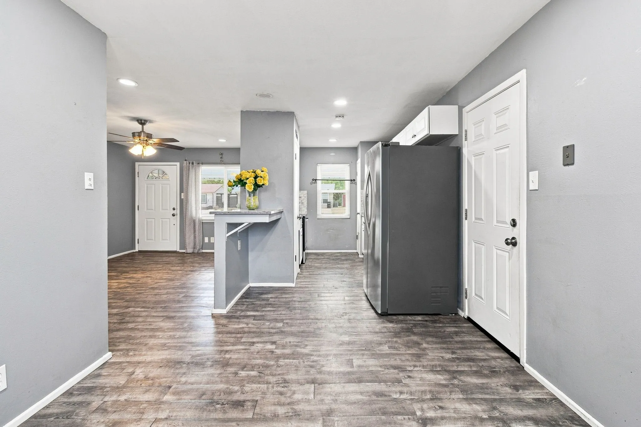 Wood-finish flooring throughout, recessed lighting, and a breakfast bar