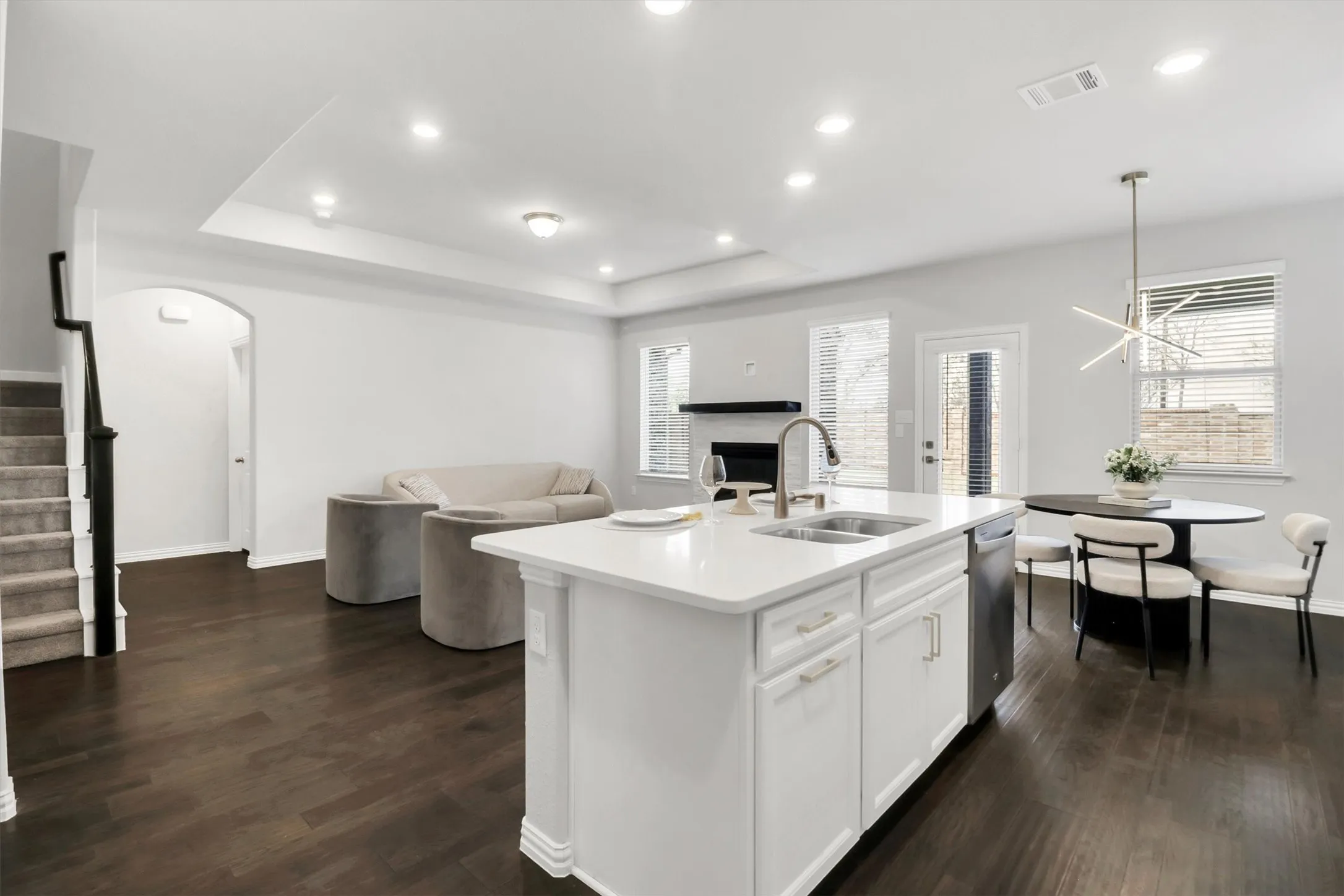 Kitchen island with integrated sink, stainless steel dishwasher, and white countertop