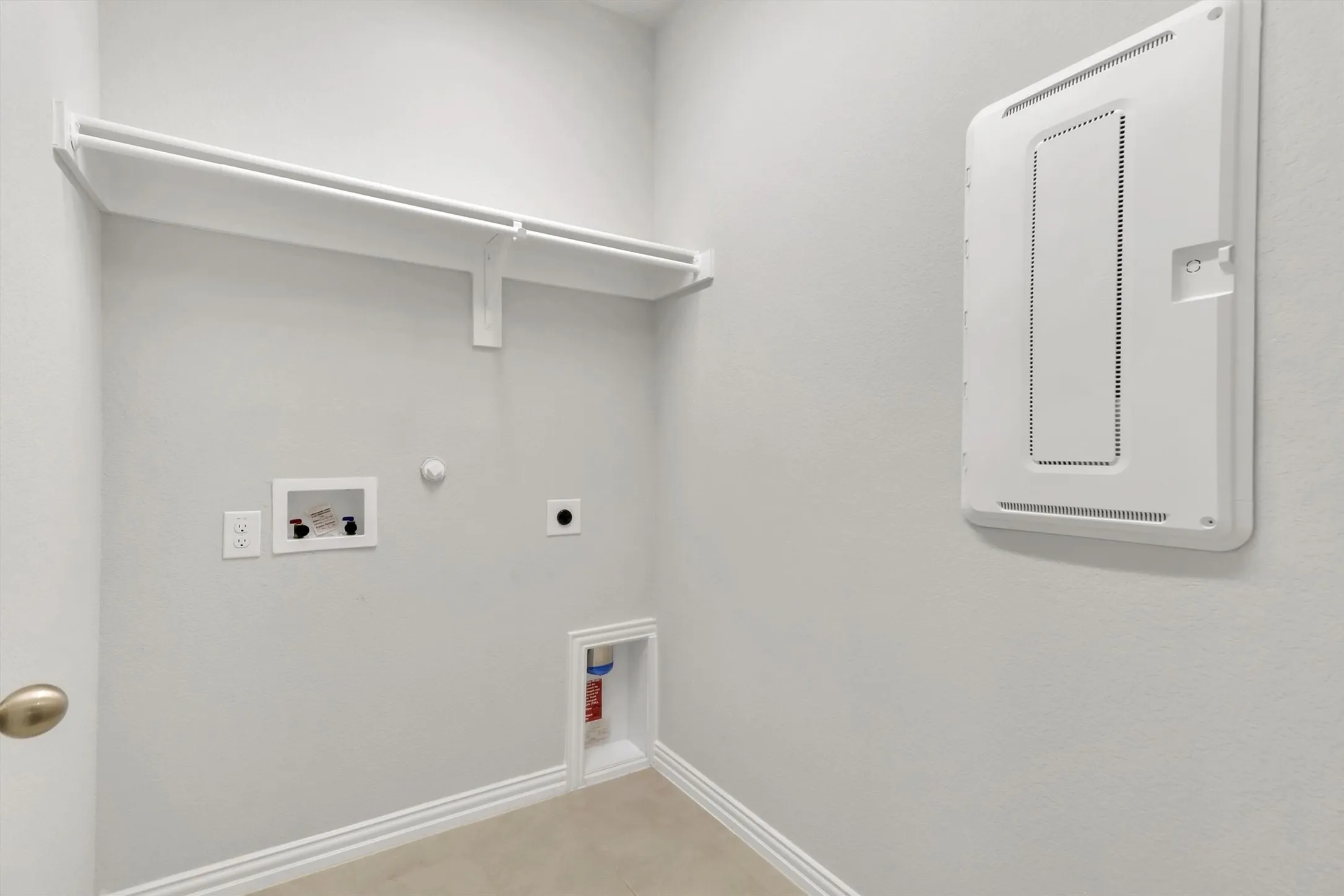 Dedicated laundry area with built-in shelving, white trim, and wall-mounted electrical panel