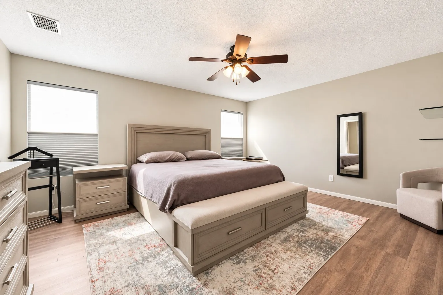 Room featuring wood-finish flooring and a ceiling fan with integrated lighting