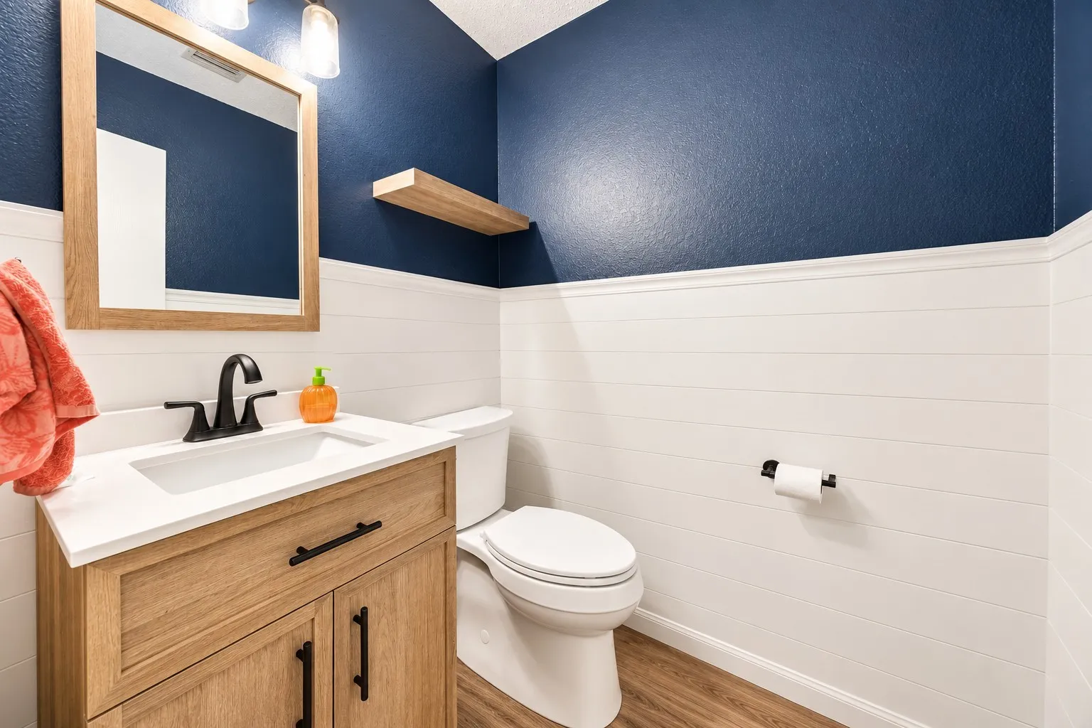 Wood-finish vanity with white countertop, integrated sink, and matte black faucet
