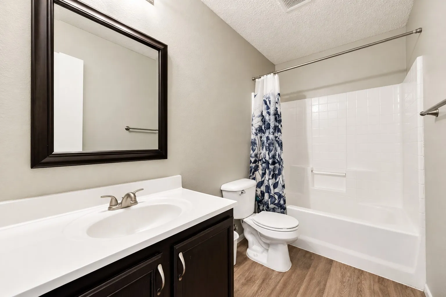 Bathroom featuring a vanity with dark wood-finish cabinetry, white countertop, and an undermount sink