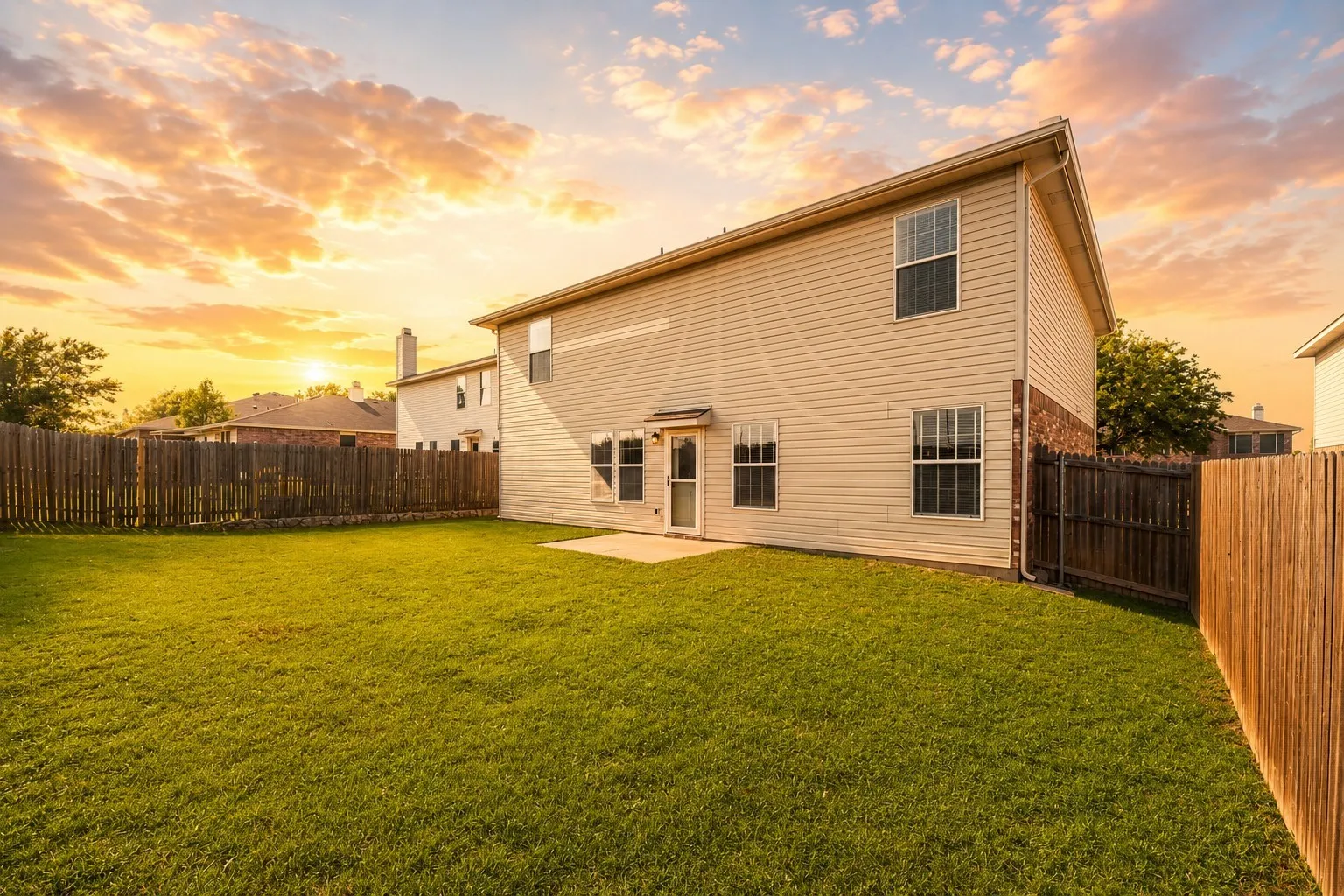 Expansive grass lawn with a full privacy fence
