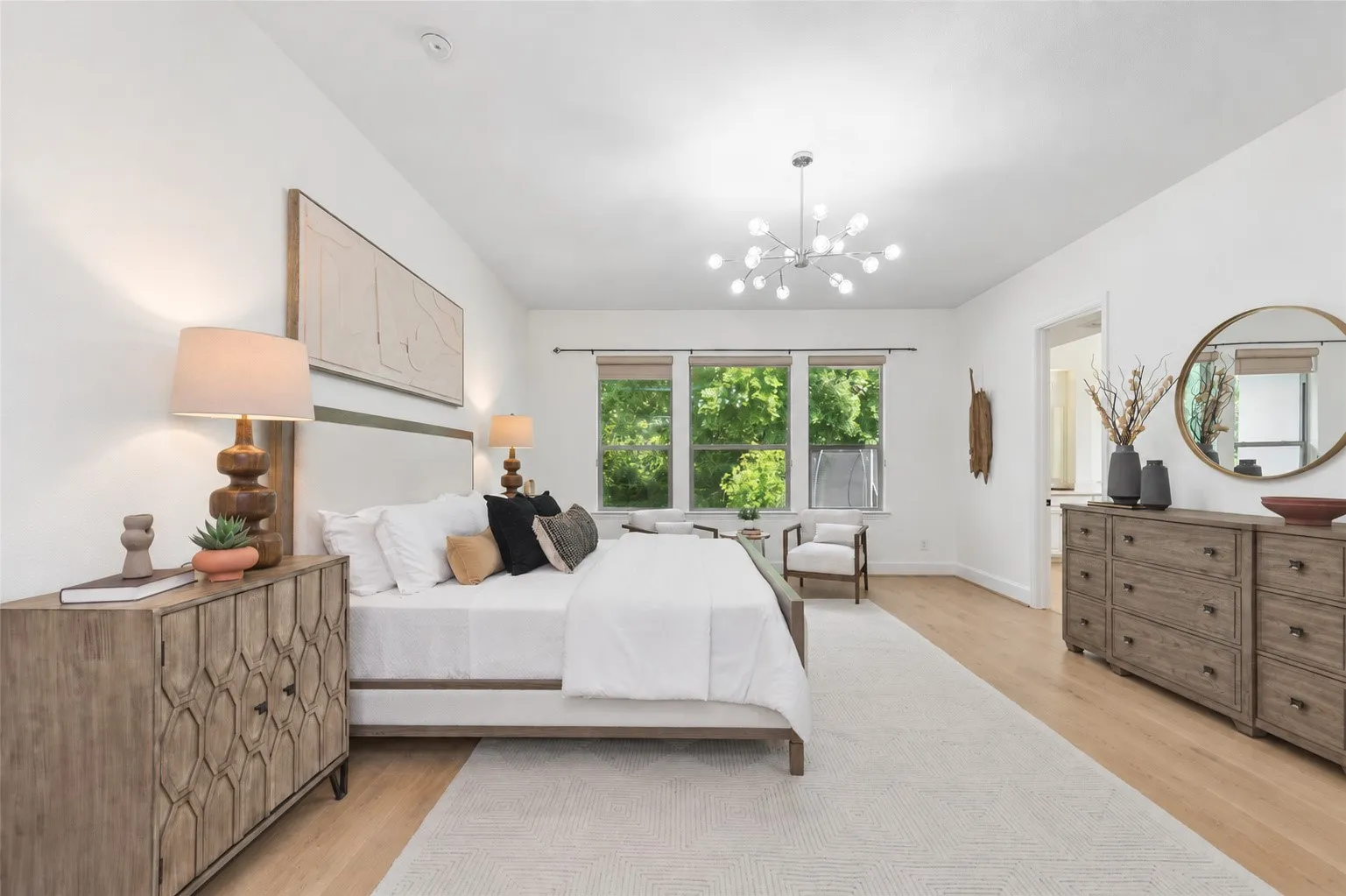 Hardwood-style flooring, white walls, and a contemporary chandelier