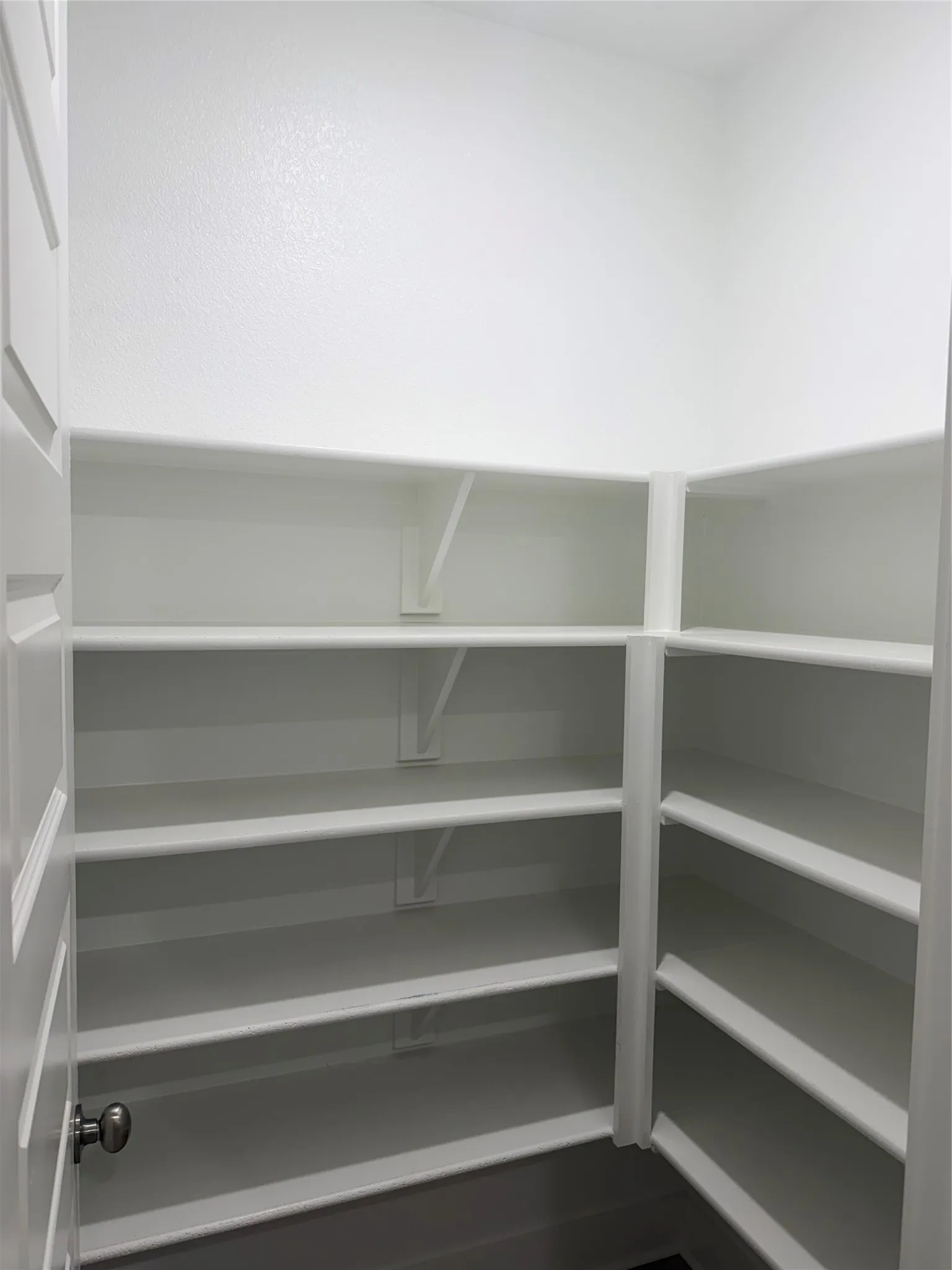 Built-in shelving with multiple levels, white finishes, and a corner configuration