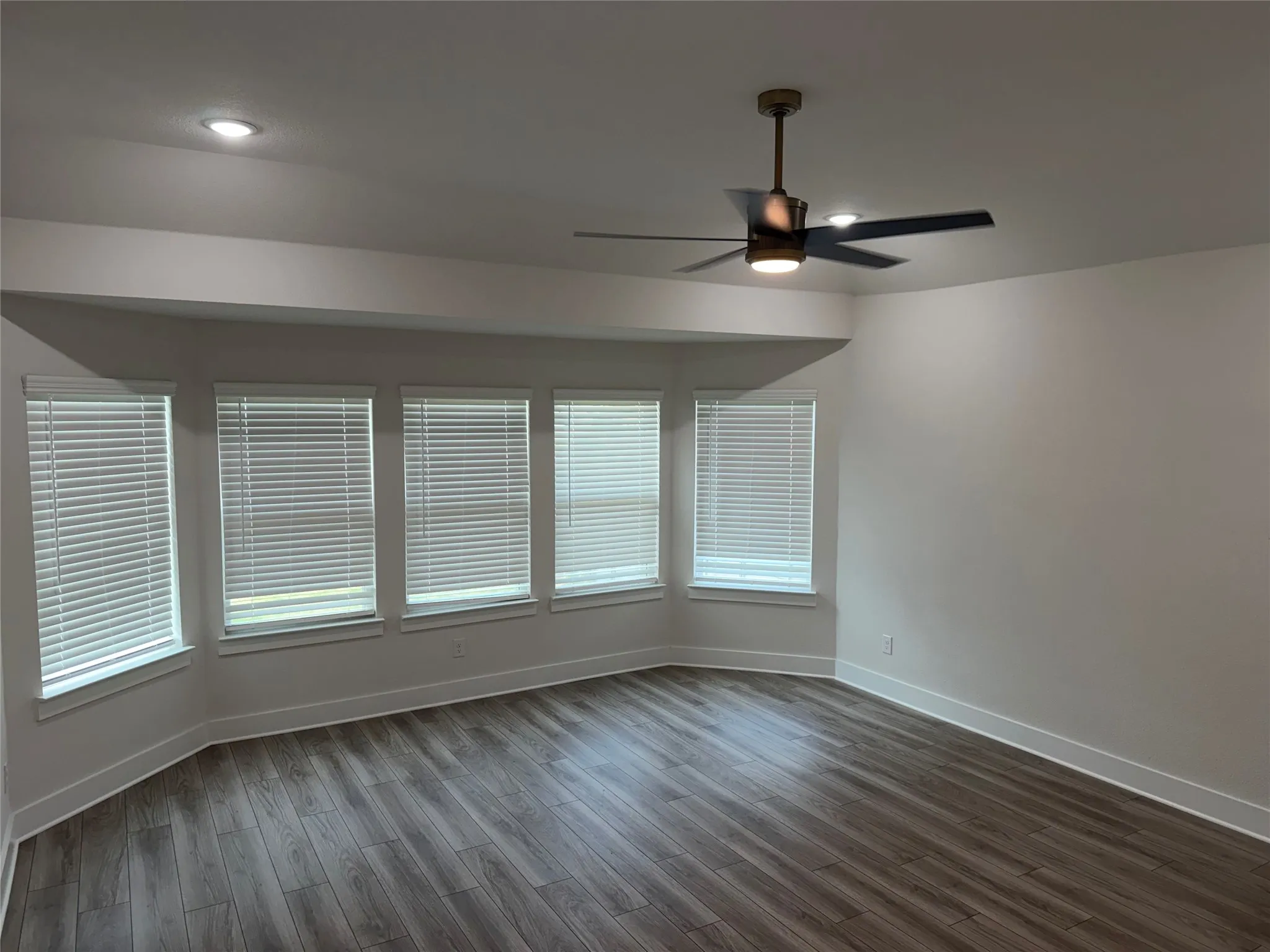 Wood-finish flooring, recessed lighting, and a modern ceiling fan
