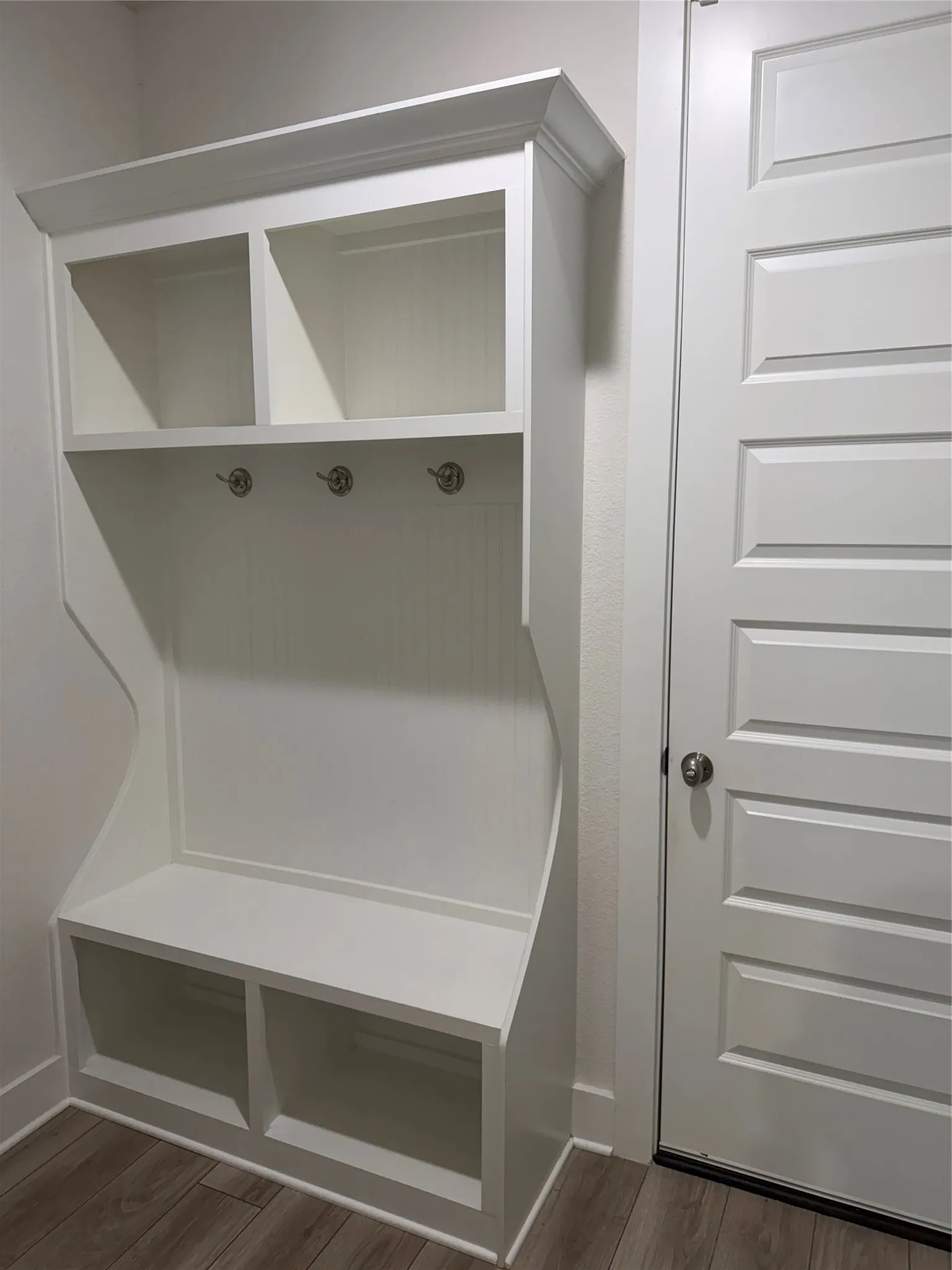 Built-in storage bench with two upper cubbies and three coat hooks