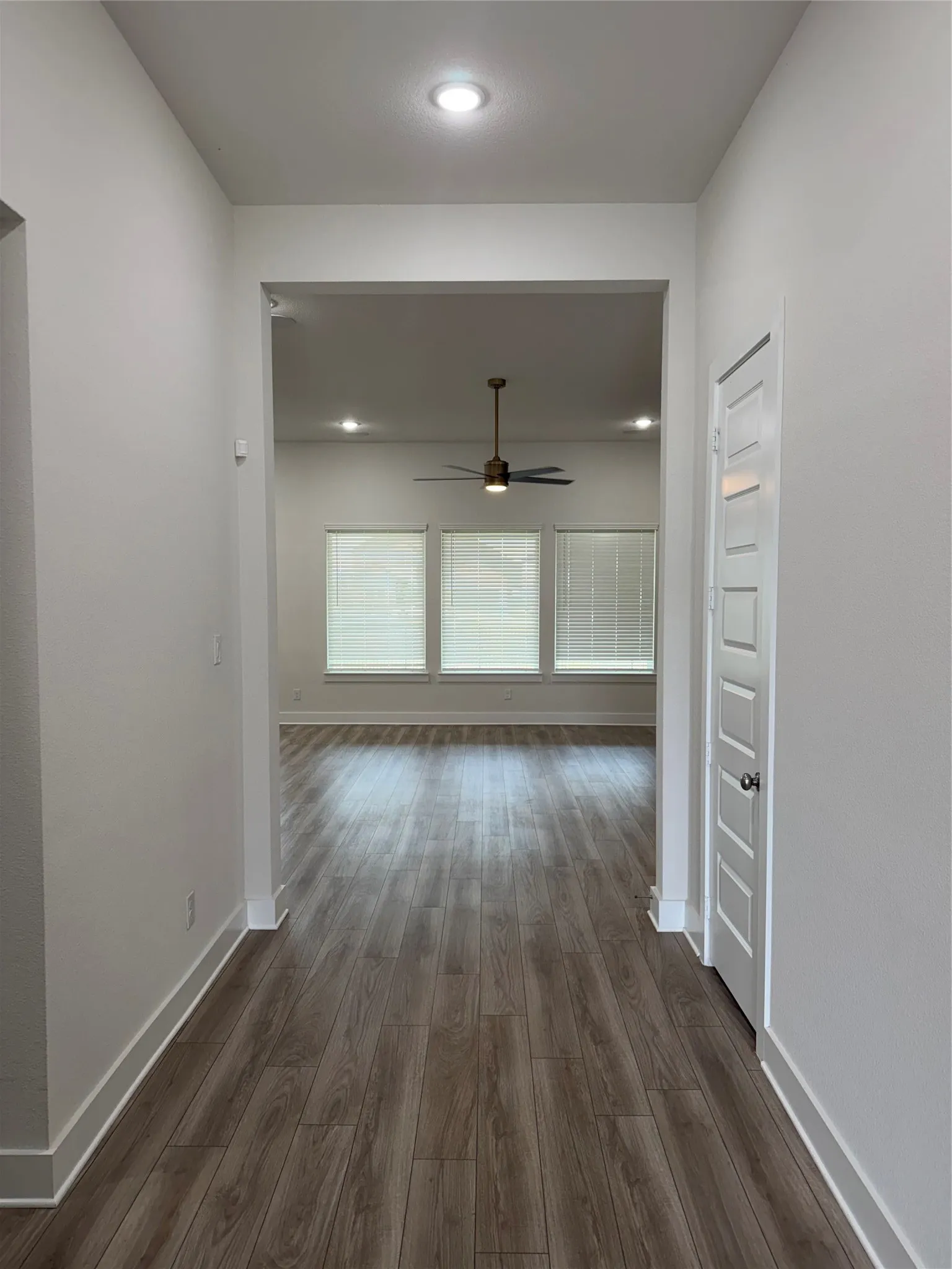 Wood-finish flooring throughout, recessed lighting, and a ceiling fan
