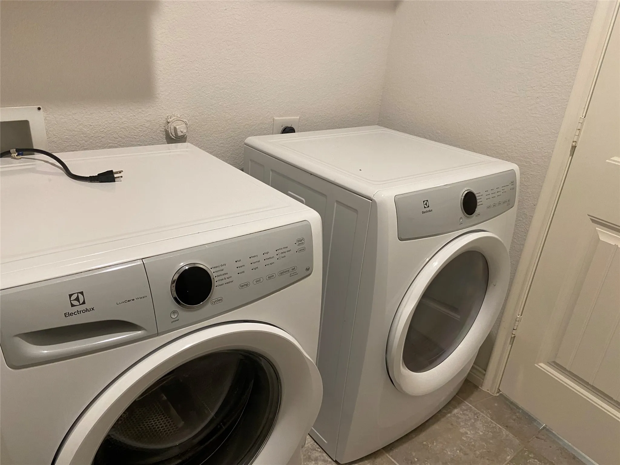 Laundry area featuring a textured wall and independent washer and dryer